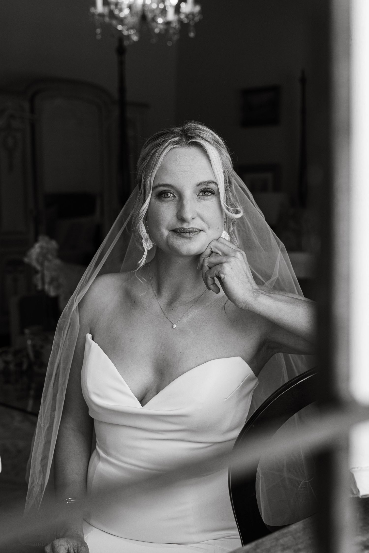 A series of black and white bridal portraits showing a bride in an elegant off-shoulder wedding dress and veil.