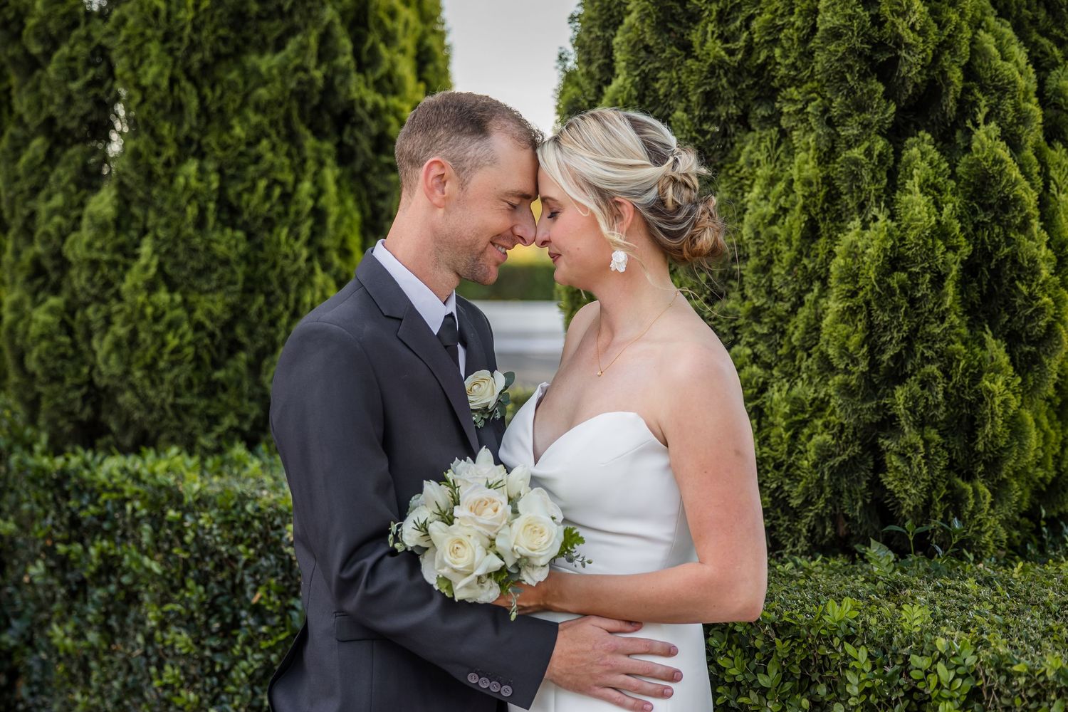 Newlyweds share romantic moments during their garden wedding photoshoot.