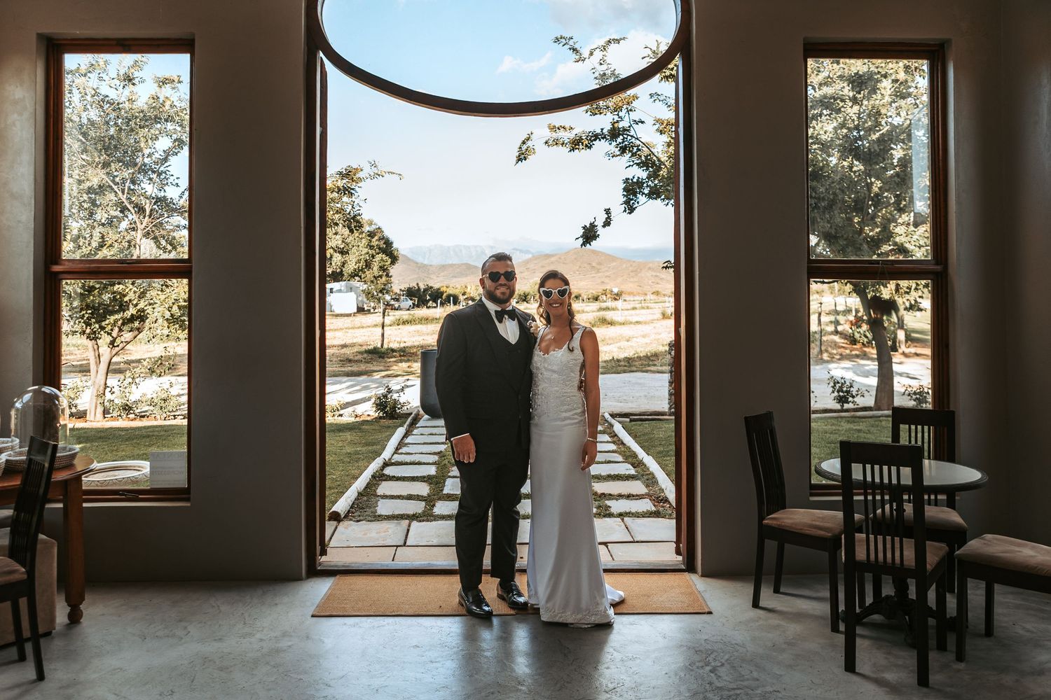 Interior view of venue with large windows overlooking outdoor ceremony space.
