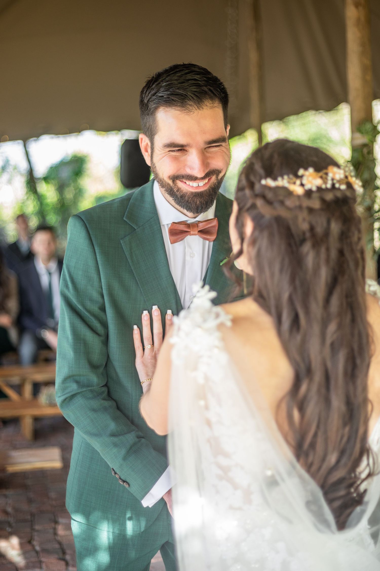 A series of wedding photos showing emotional first look moments between a bride and groom in a green suit jacket.