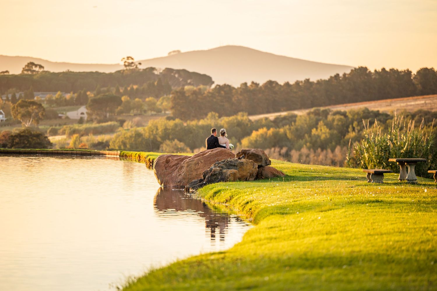 Panoramic view of a couple on rolling hills during sunset wedding photography session.
