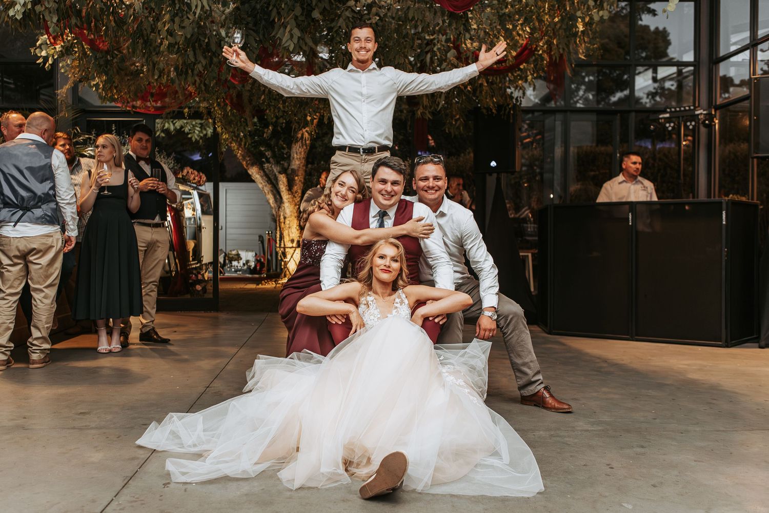 Wedding celebration with dancing and fog effects in modern indoor venue.