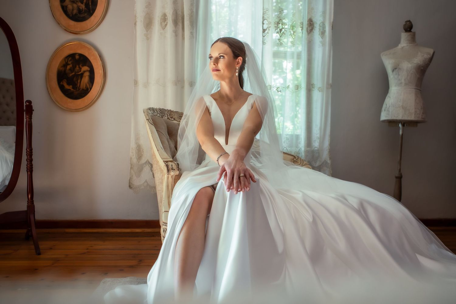 Elegant bridal portrait in a sunlit room with vintage decor and white dress.