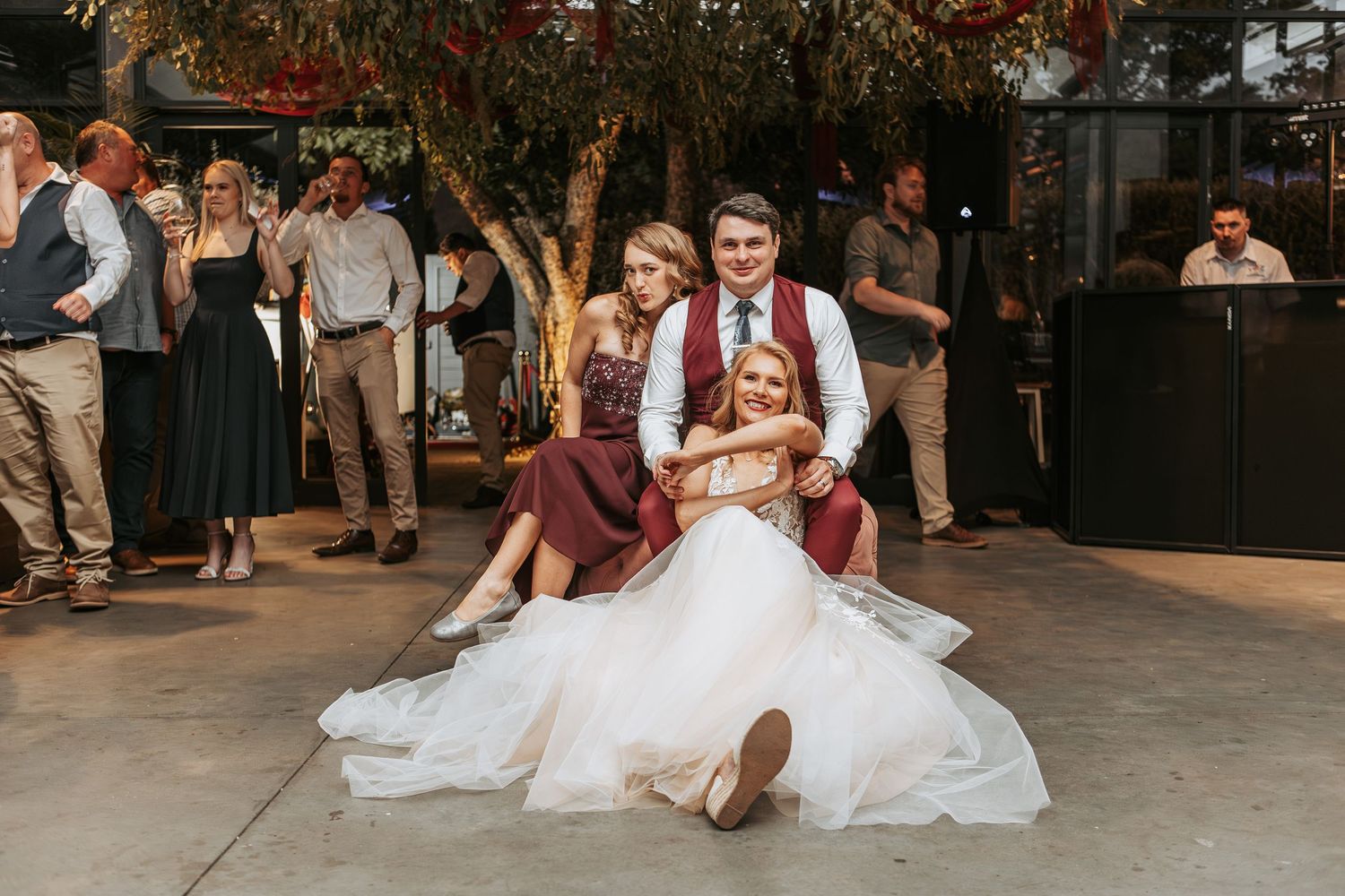 Wedding reception dance floor scene with guests celebrating outdoors.