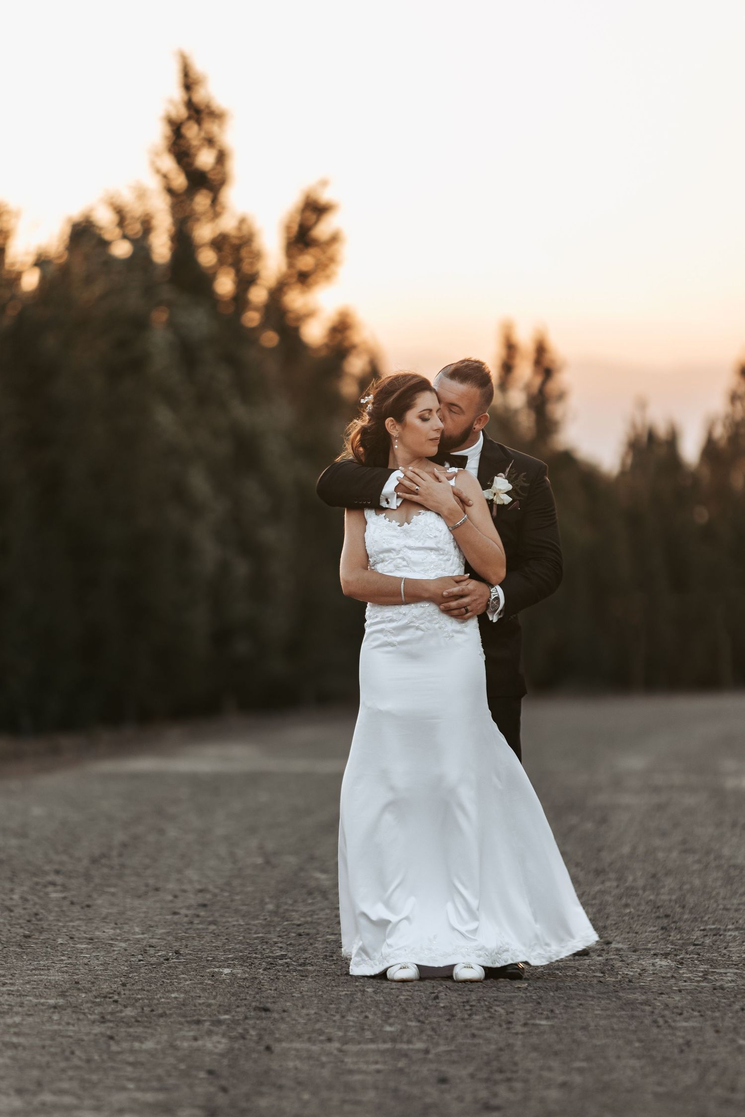 Intimate wedding portraits captured at dusk in a desert setting.