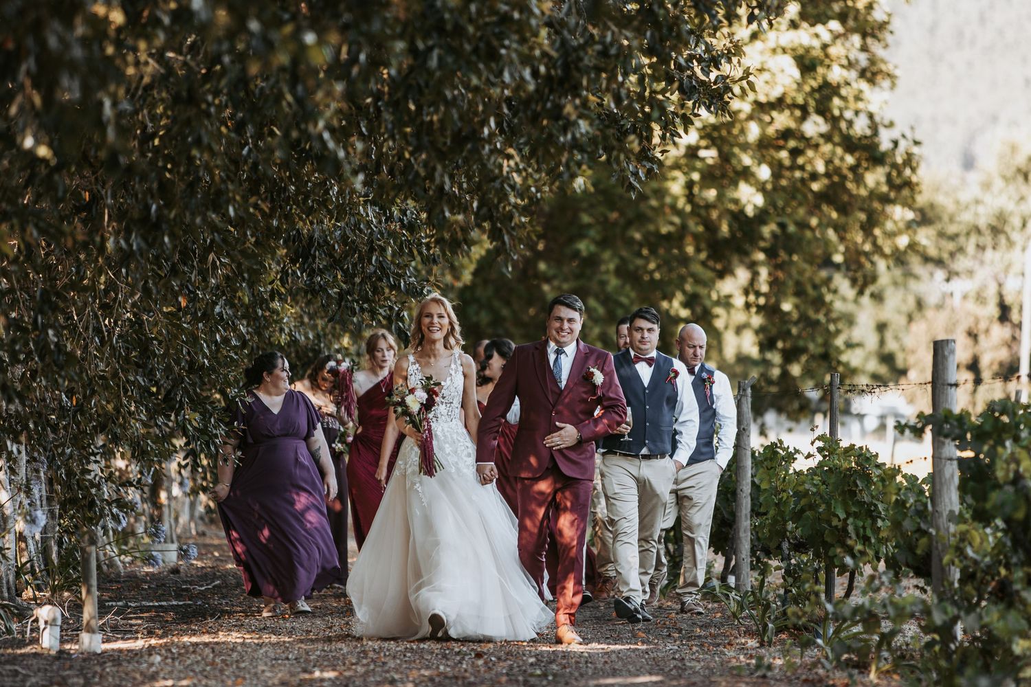 Wedding guests celebrating and cheering during an outdoor garden ceremony.