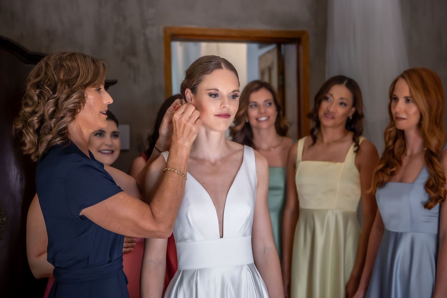 Wedding party poses together in an elegant indoor space with warm lighting.