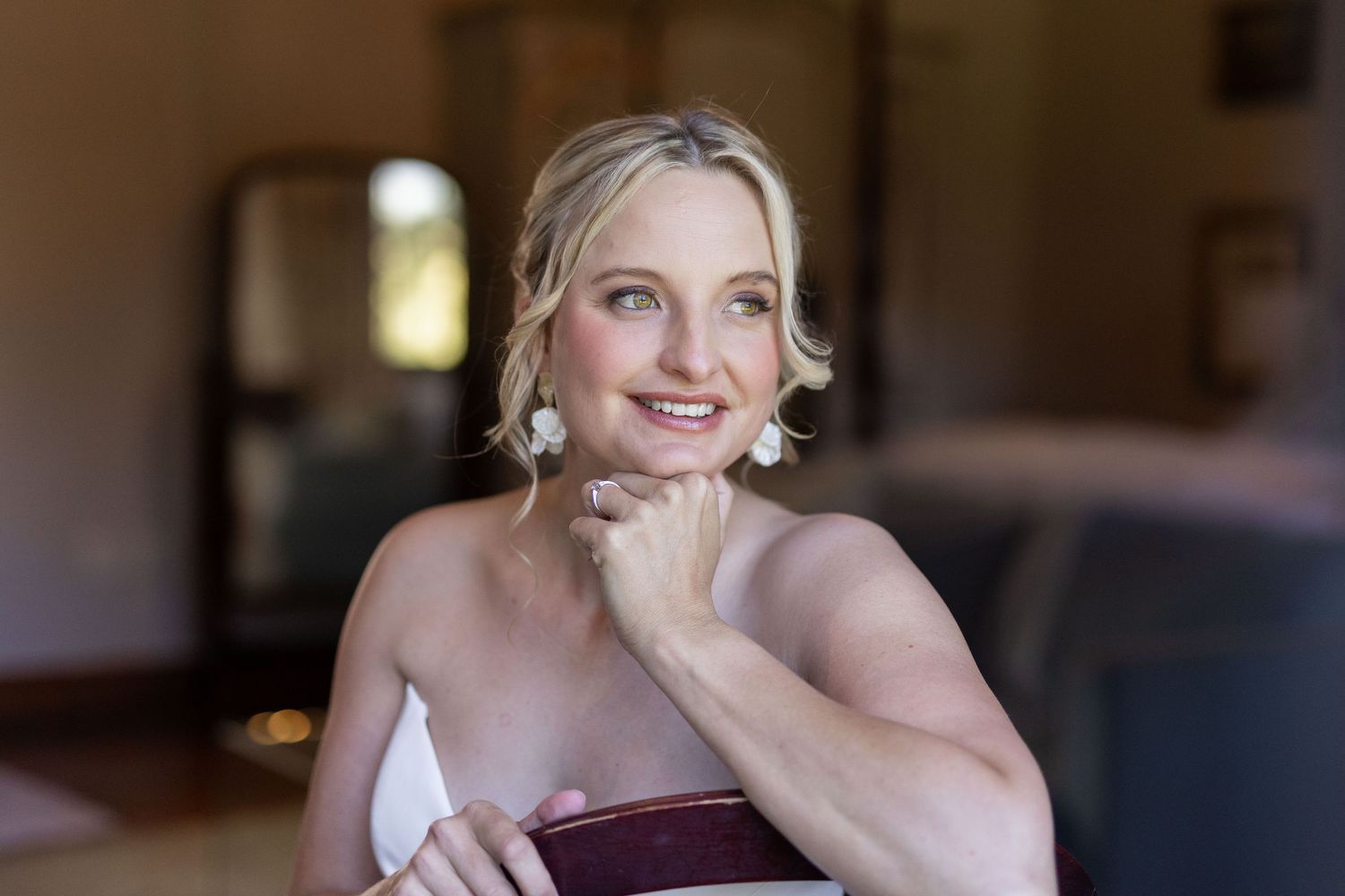 Candid moments of bridal preparation showing joyful expressions in natural window light.