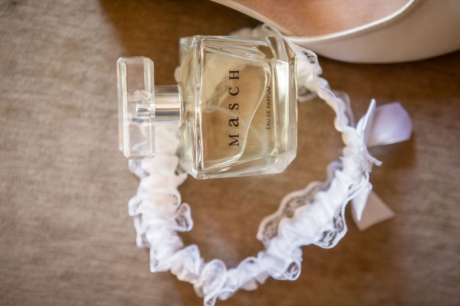 Wedding detail shot of perfume bottles and delicate lace accessories.