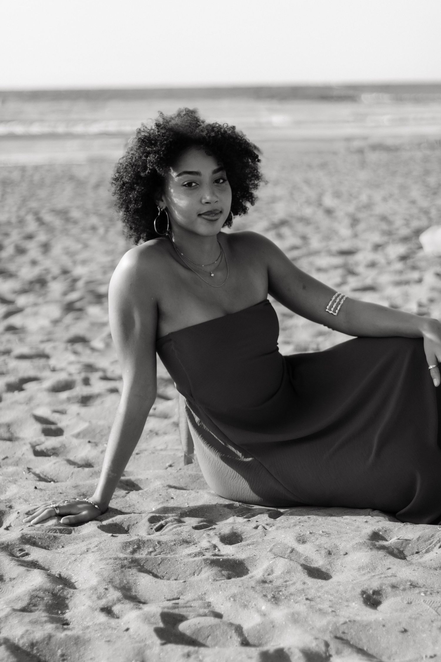 Black and white beach photography with elegant black dress on sandy shoreline located at Edgewater Beach in Cleveland, OH