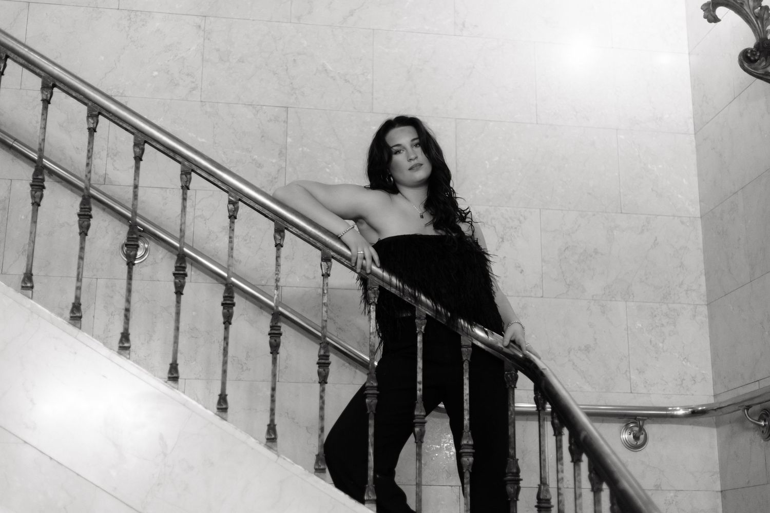 Black and white photos show a person posing on stairs in vintage style clothing and dramatic lighting during her senior photos
