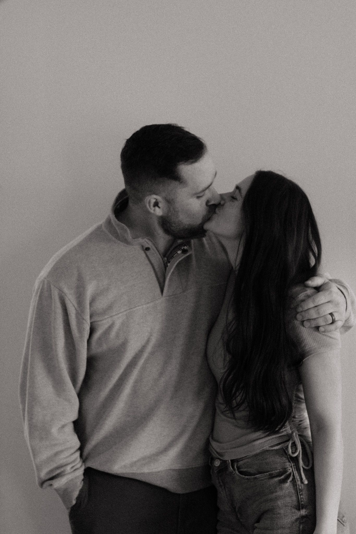 Black and white artistic photo series showing couple in intimate poses against wall.