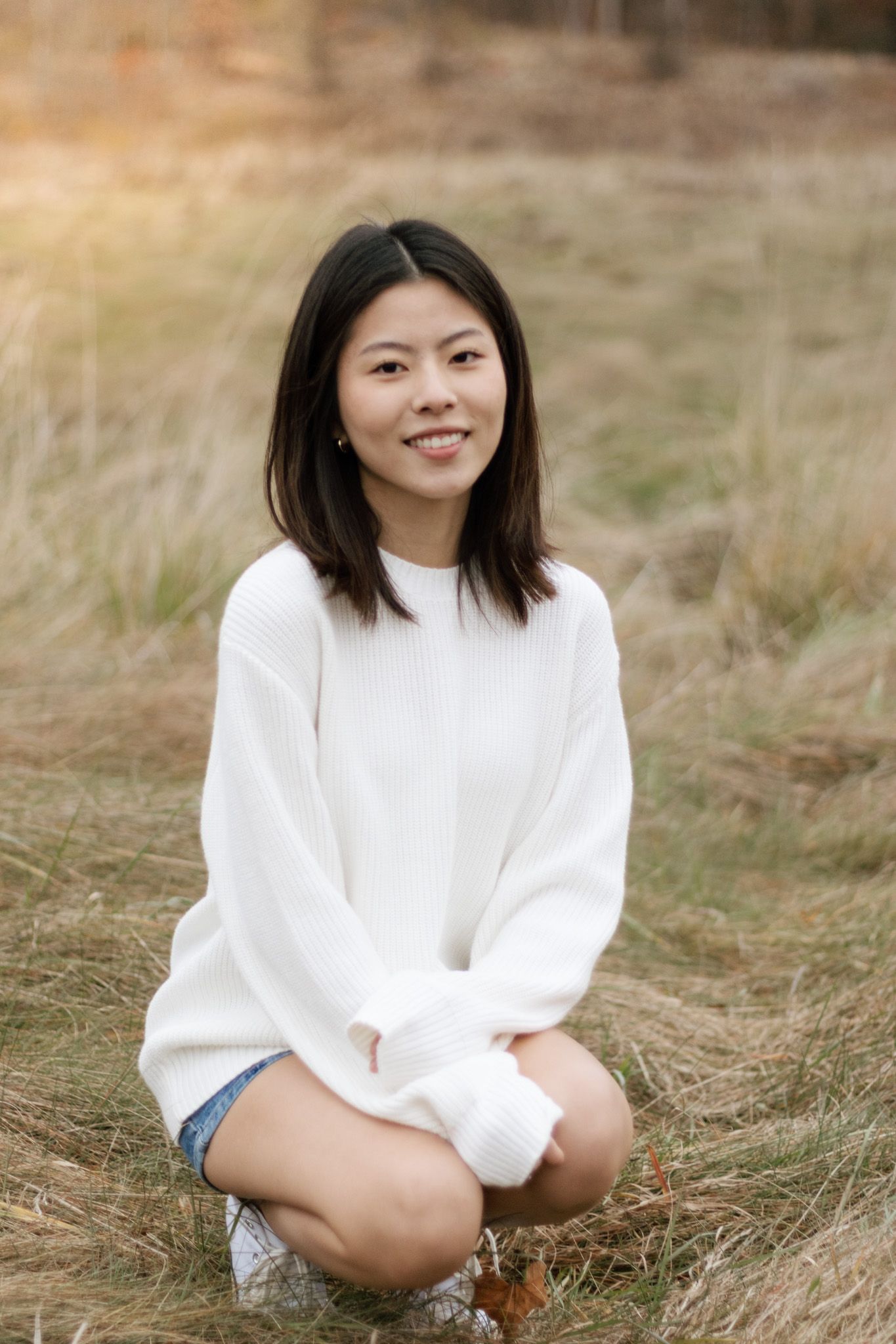 Casual portrait session in a golden grass field during sunset.