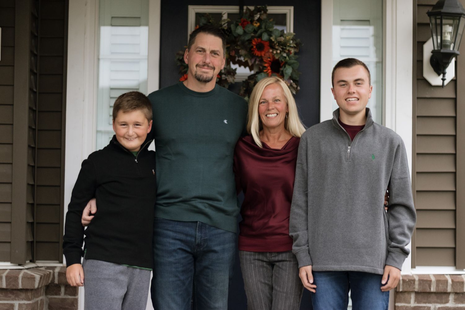 Extended family poses together outdoors in casual clothing for a group portrait for their family photoshoot in Hudson, OH