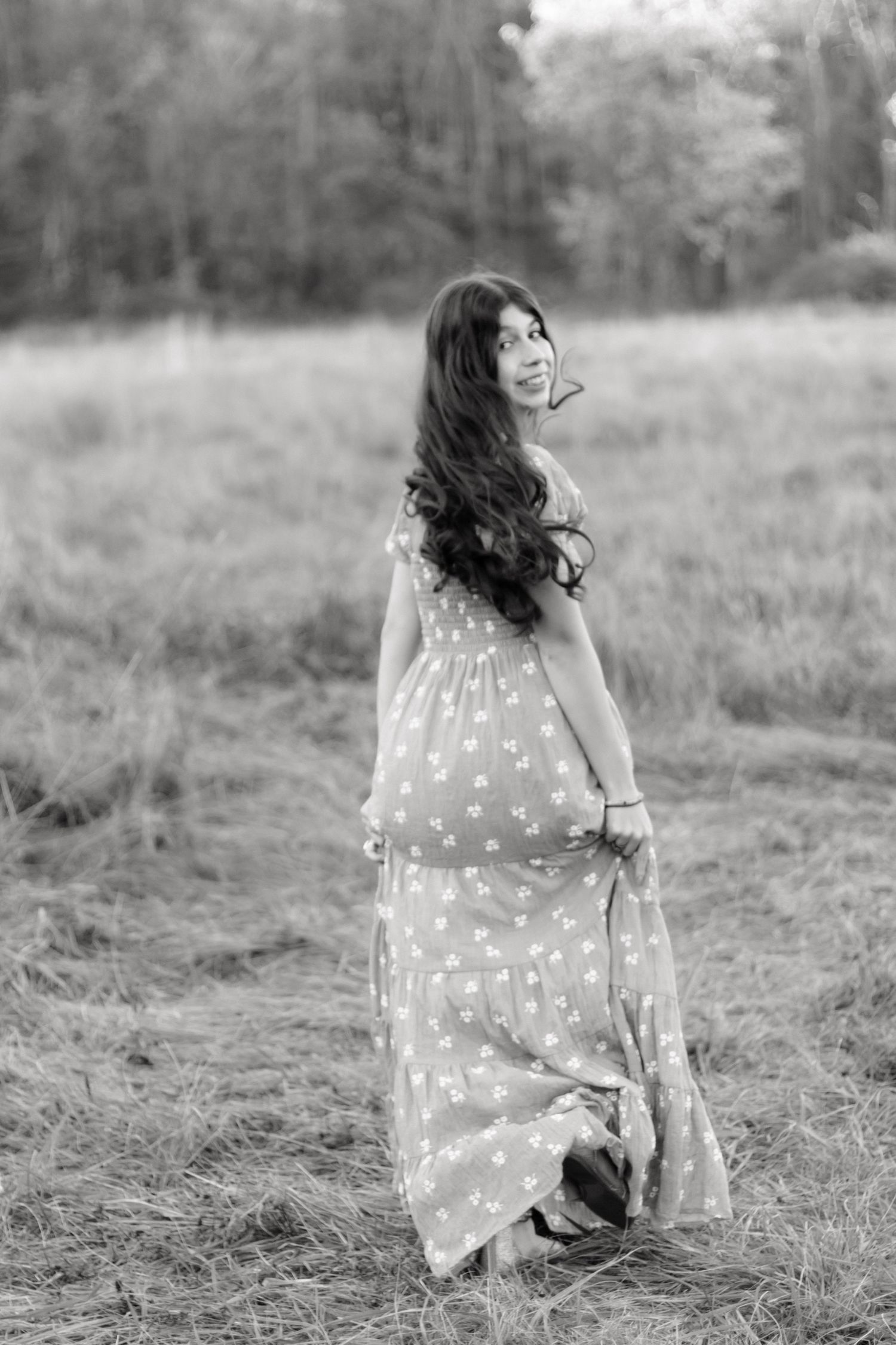 Black and white portrait series of someone in a polka dot dress twirling in a field.