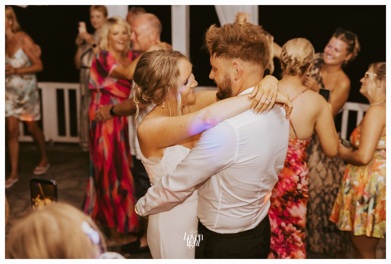 Energetic wedding reception dance floor with guests celebrating.