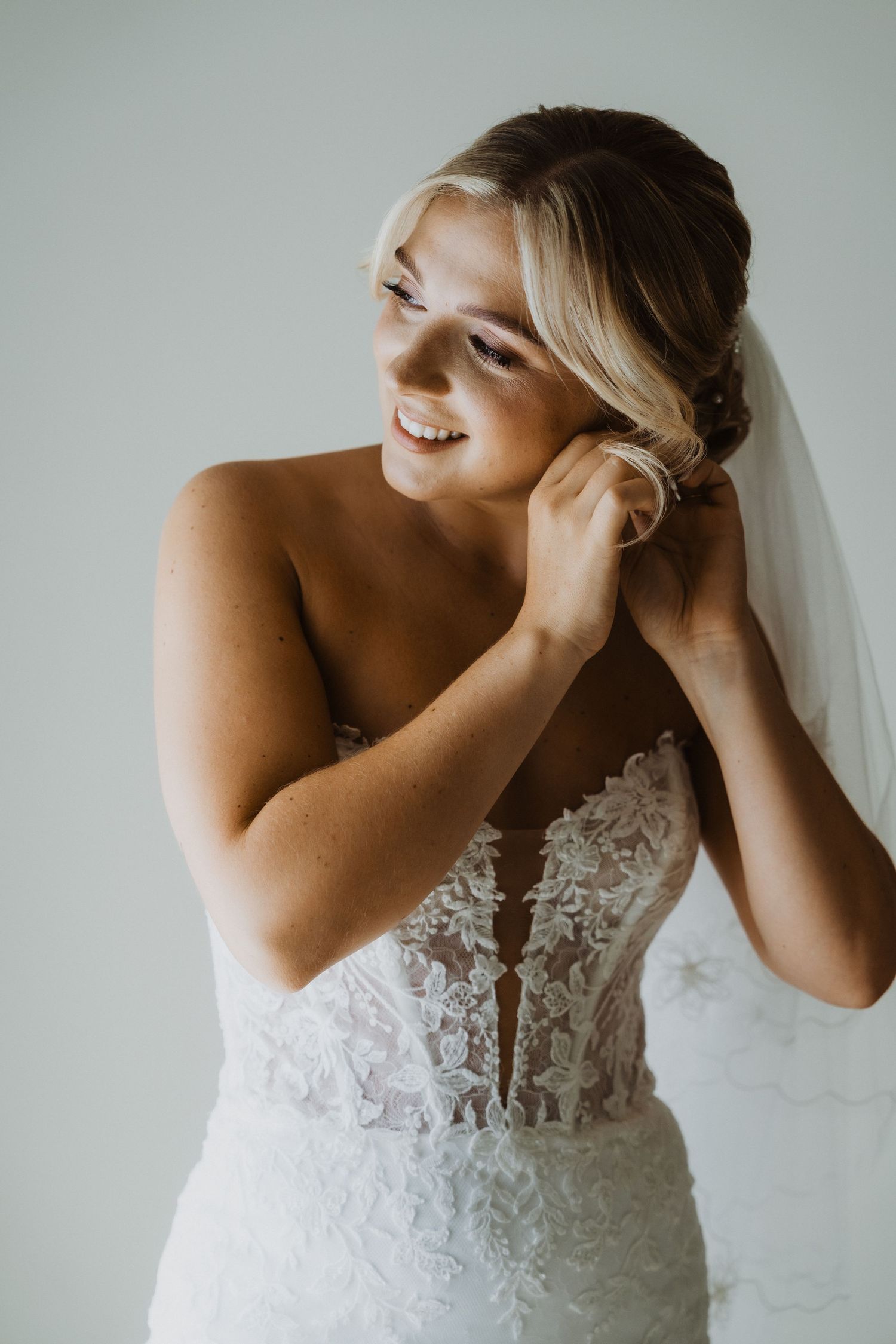 Bridal preparation moments showing detailed lace wedding gown.