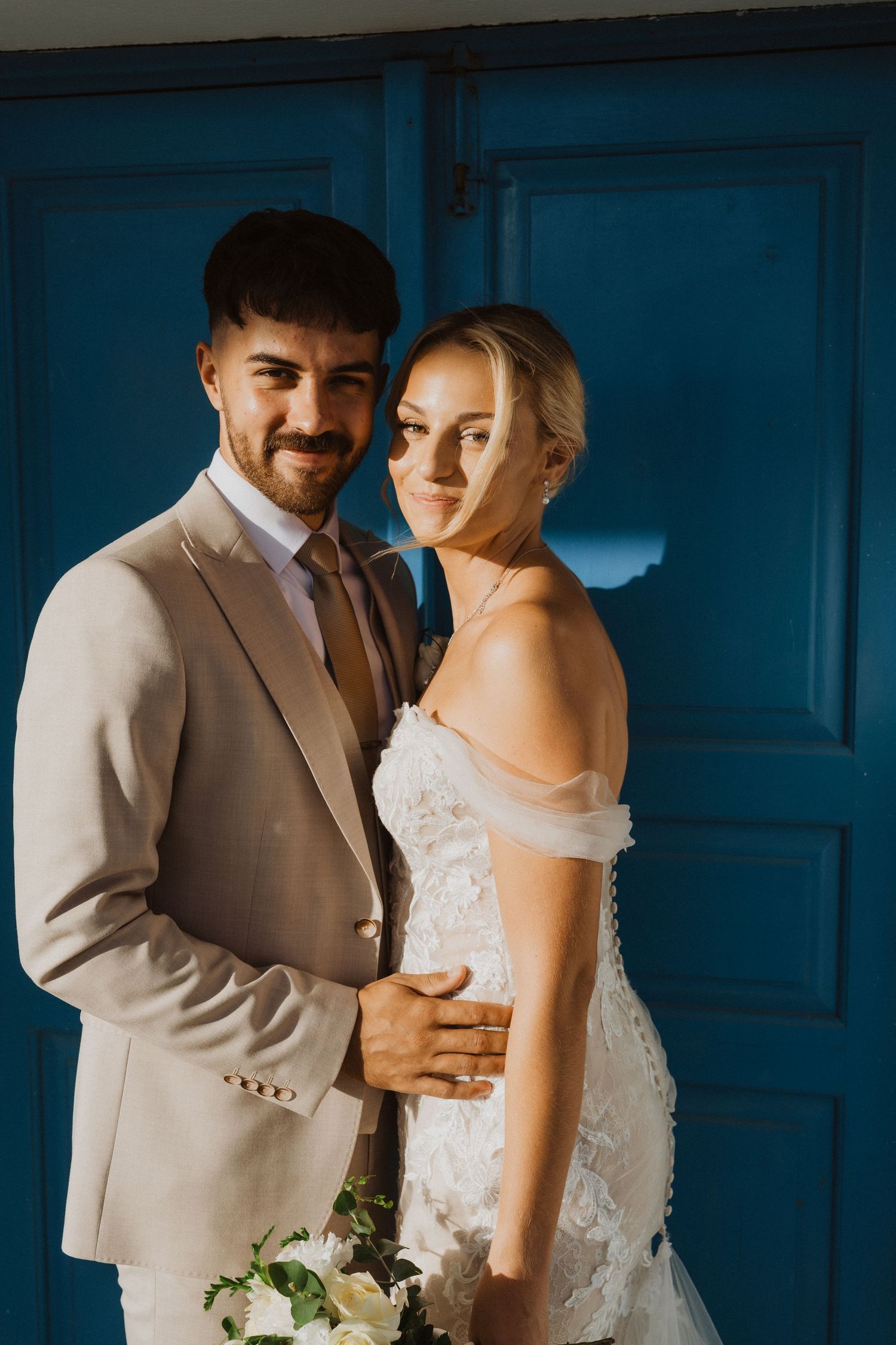 Intimate wedding portraits against vibrant blue doors showcase the couple's special moments.