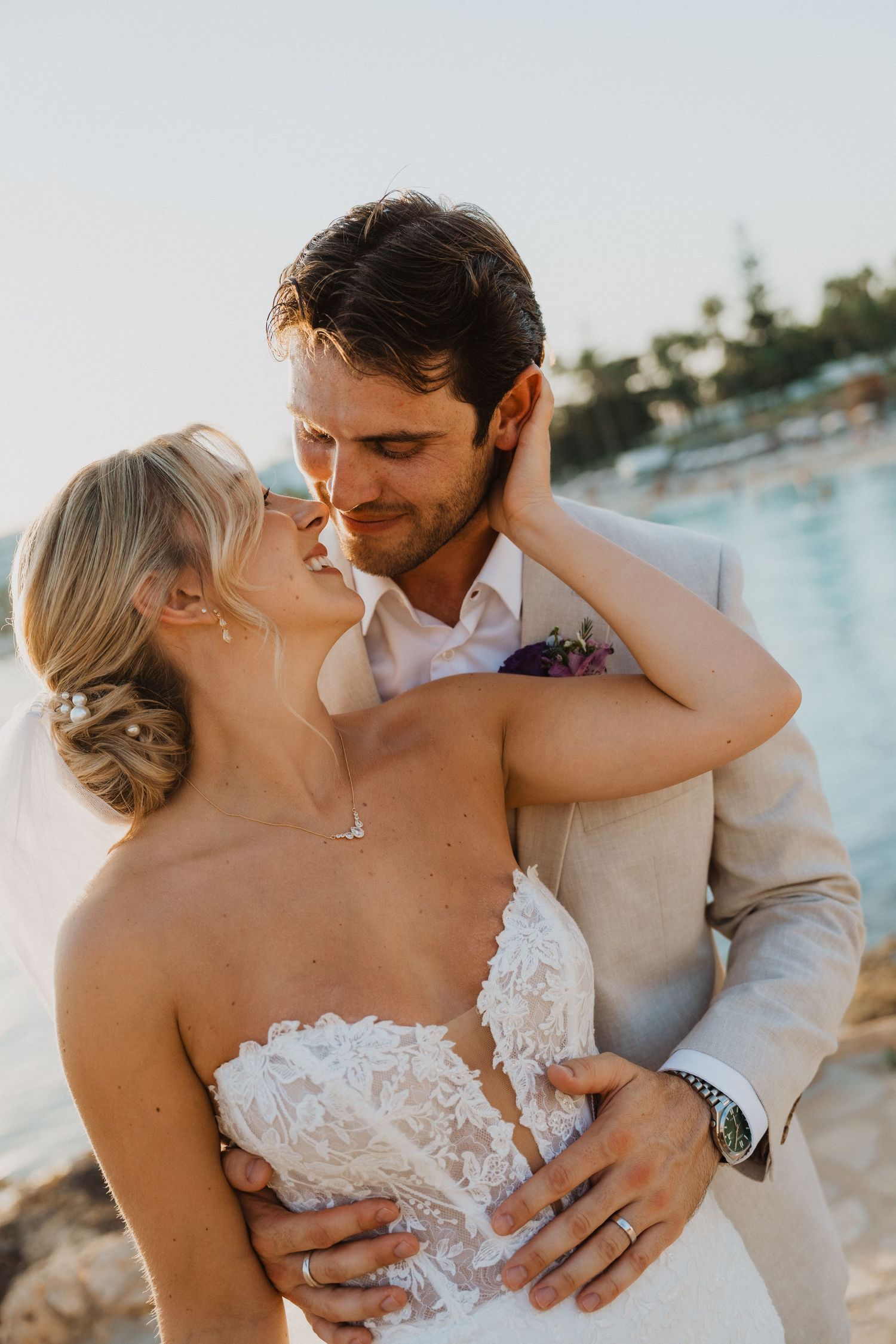 A tender moment between newlyweds sharing an intimate embrace by the sea.