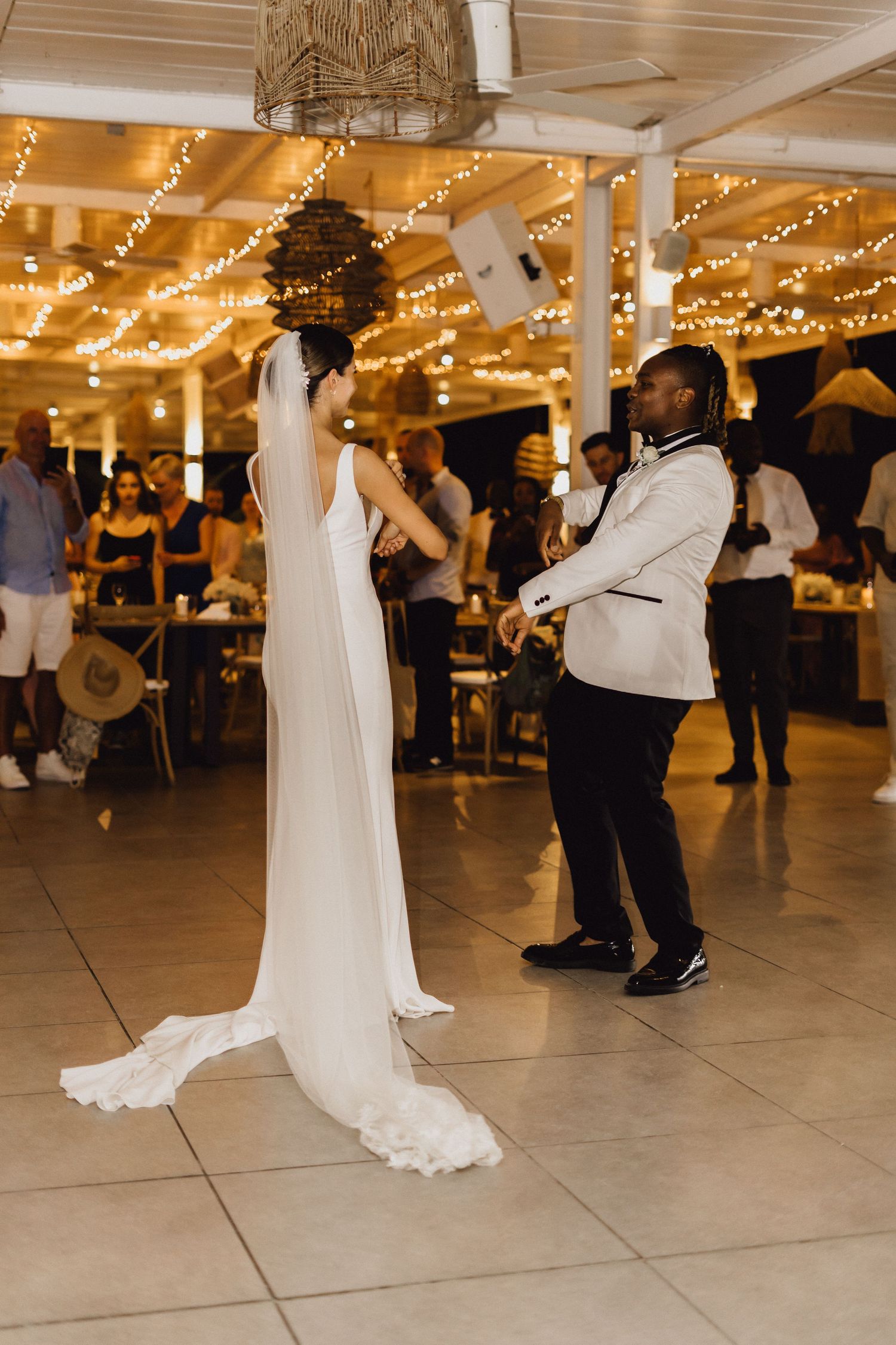 A bride in a flowing white gown dances during her wedding reception.