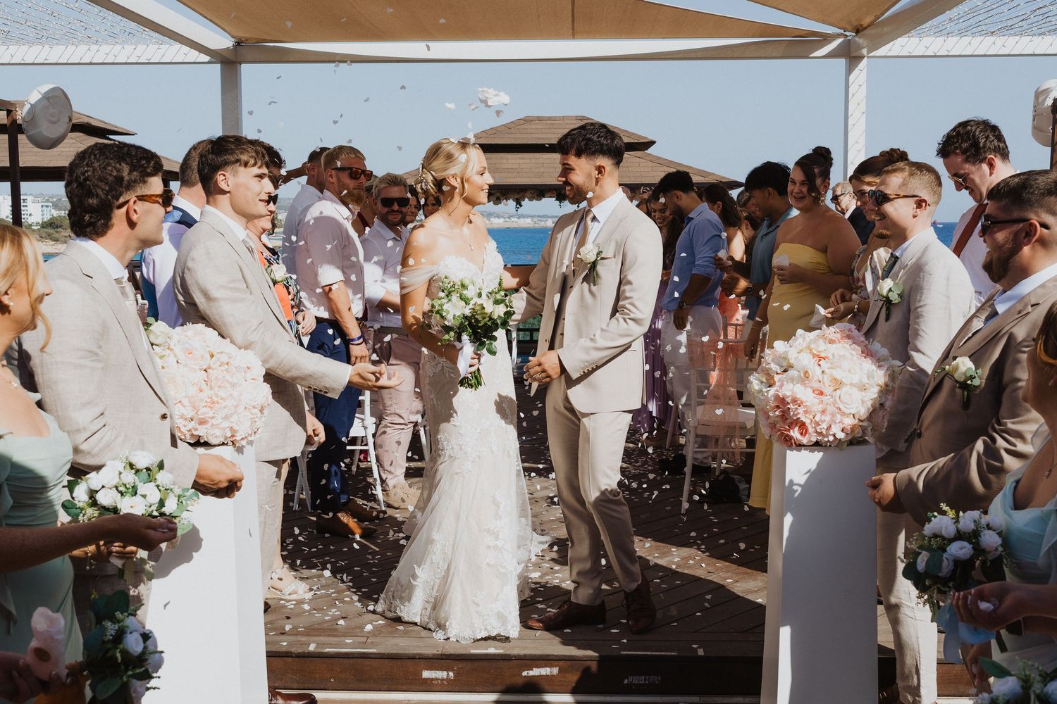 Wedding celebration with guests throwing confetti during outdoor reception.