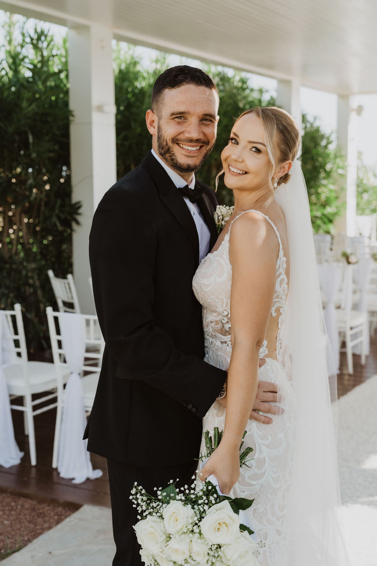 A romantic wedding photoshoot series on a white porch with classic rocking chairs in the background.