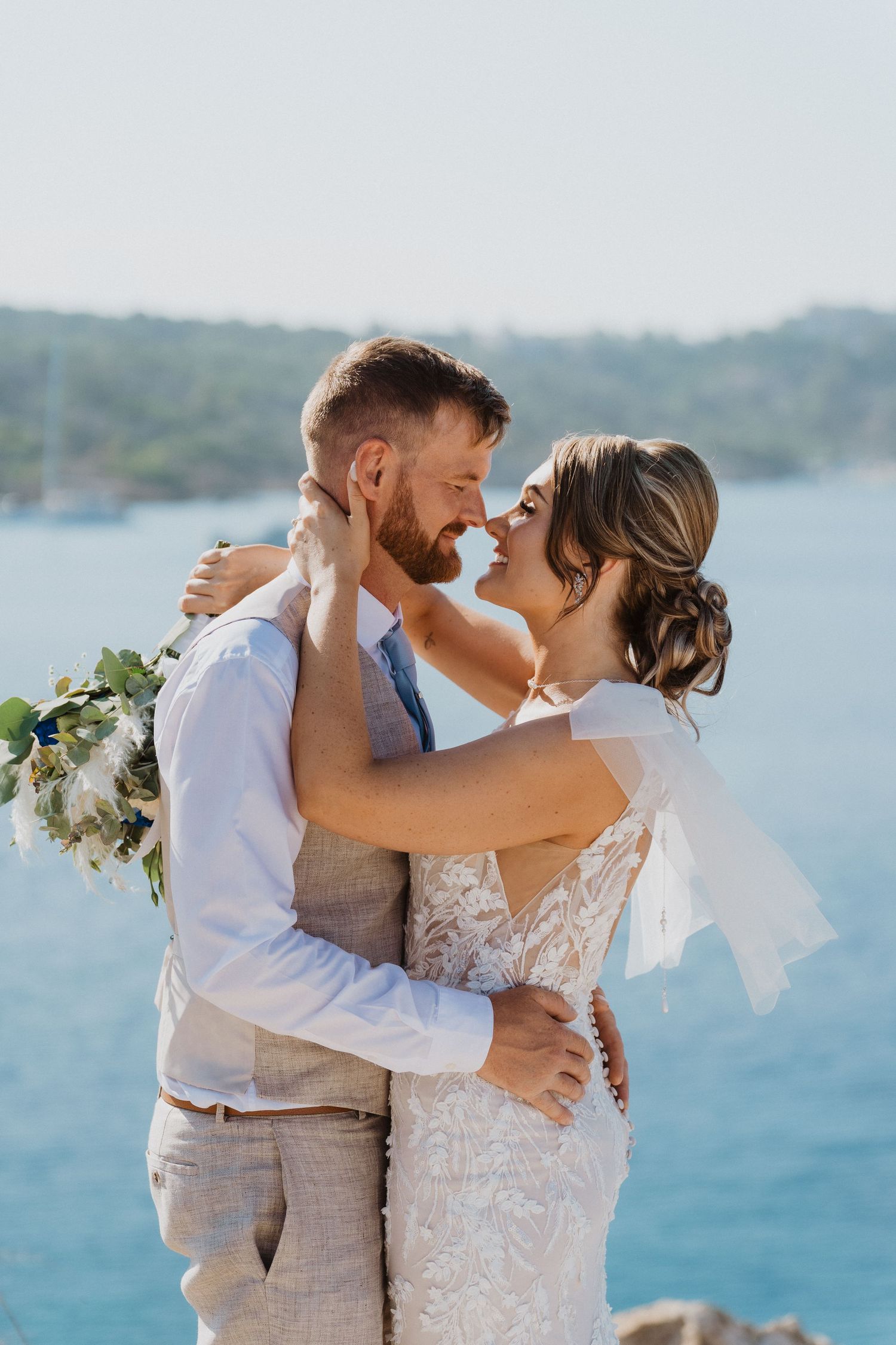 Romantic wedding portrait with turquoise ocean waters in background.