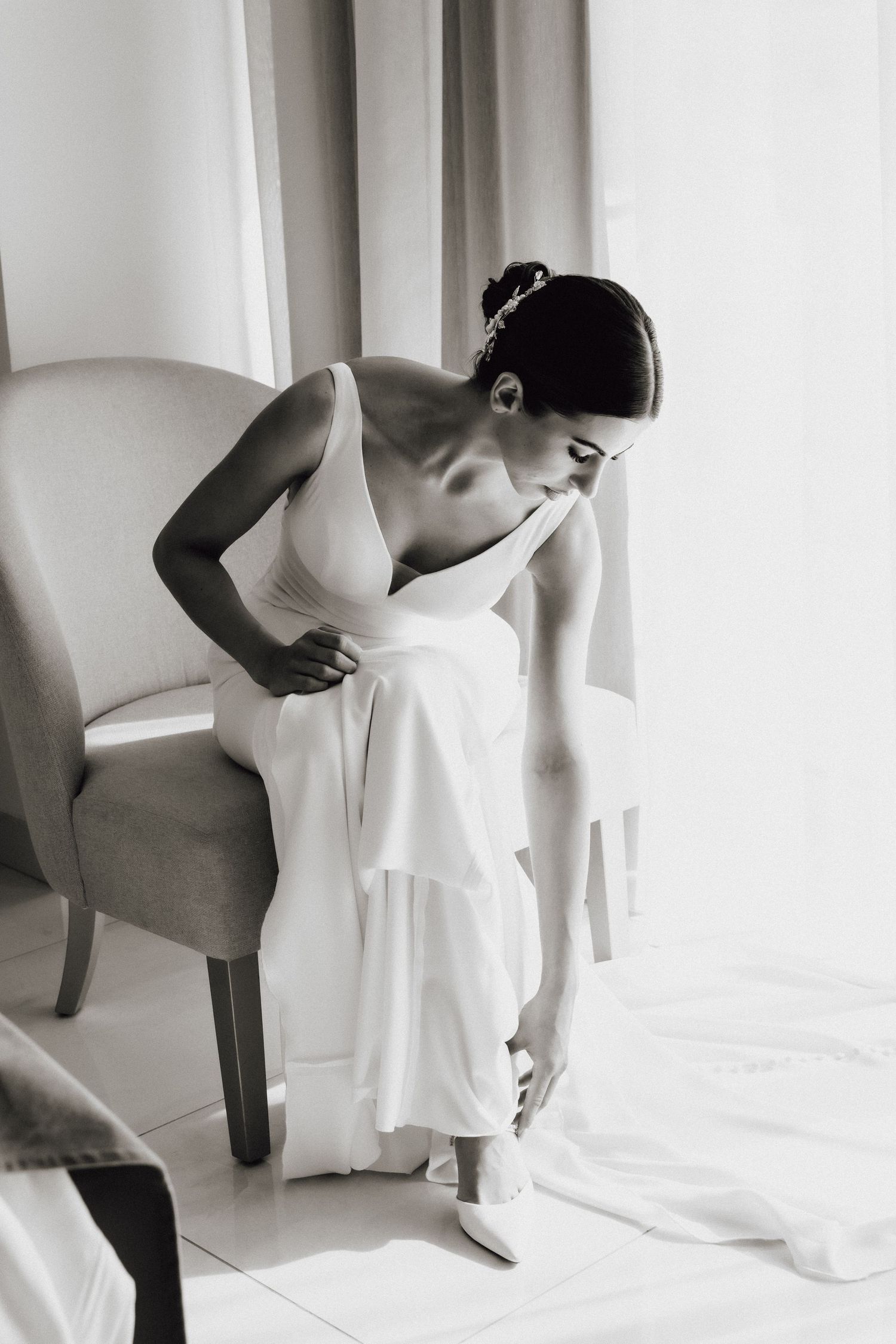 Black and white photo of bridal preparations showing elegant dress details.
