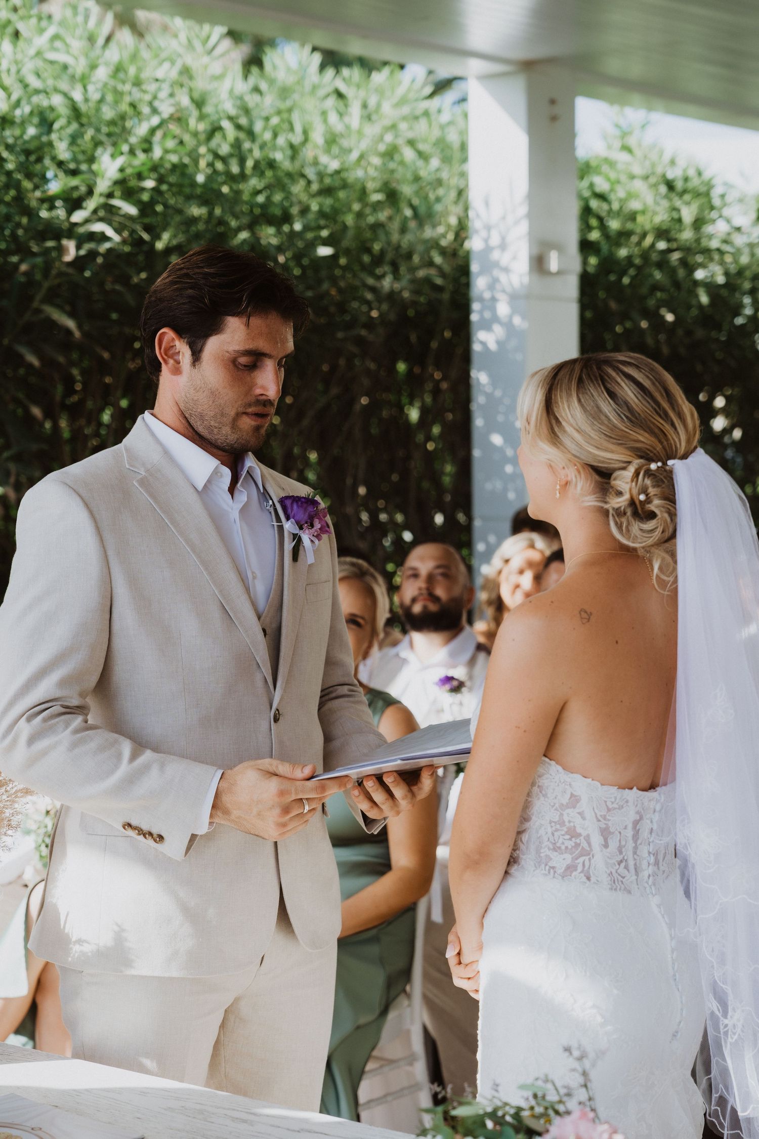 Elegant outdoor wedding ceremony with white and beige color scheme under a covered pavilion.