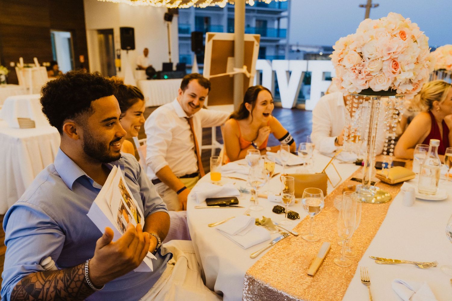 Wedding reception dinner with guests seated at decorated tables.