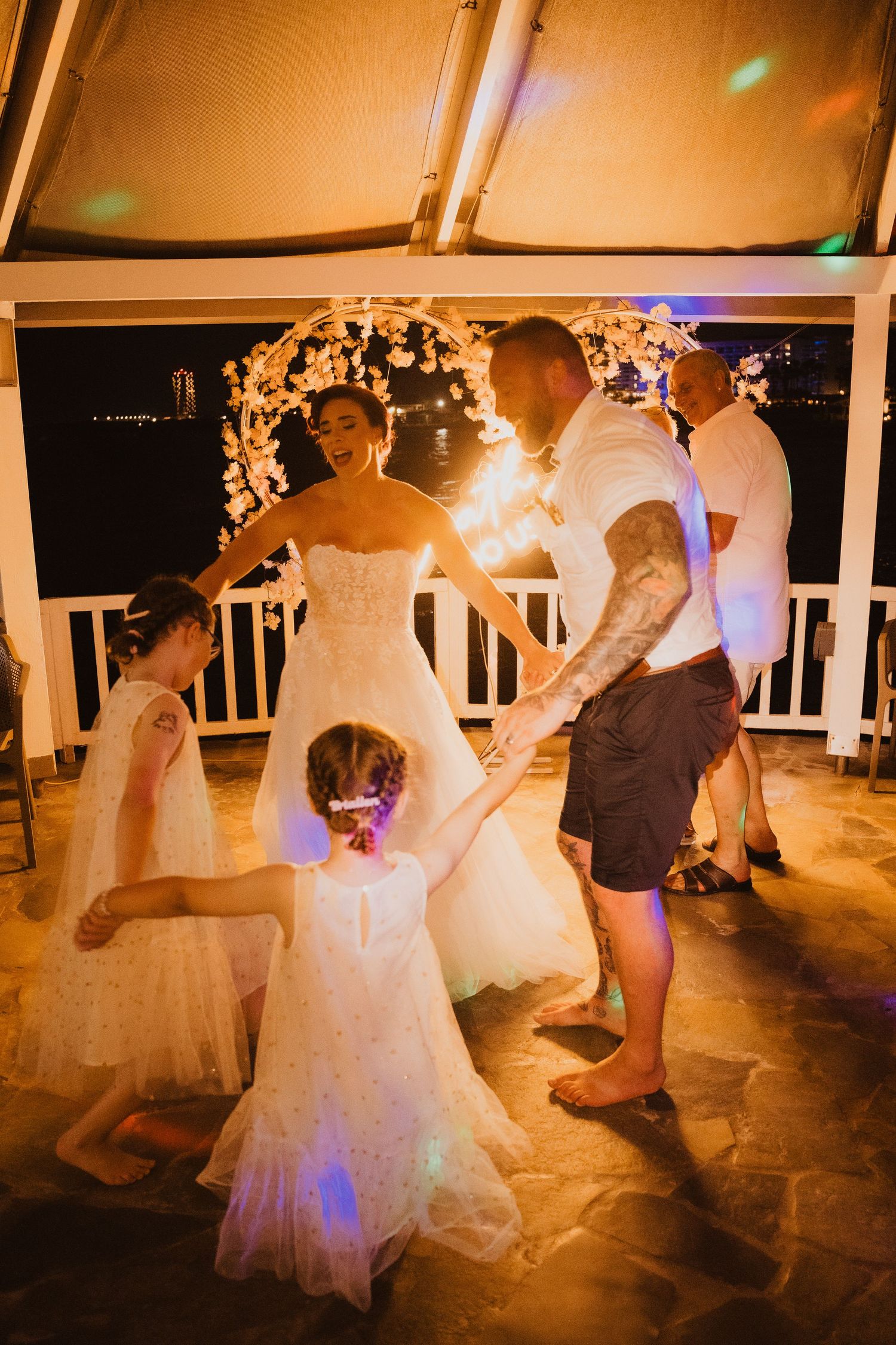 An evening wedding reception dance with string lights and decorative arches creating a warm atmosphere.