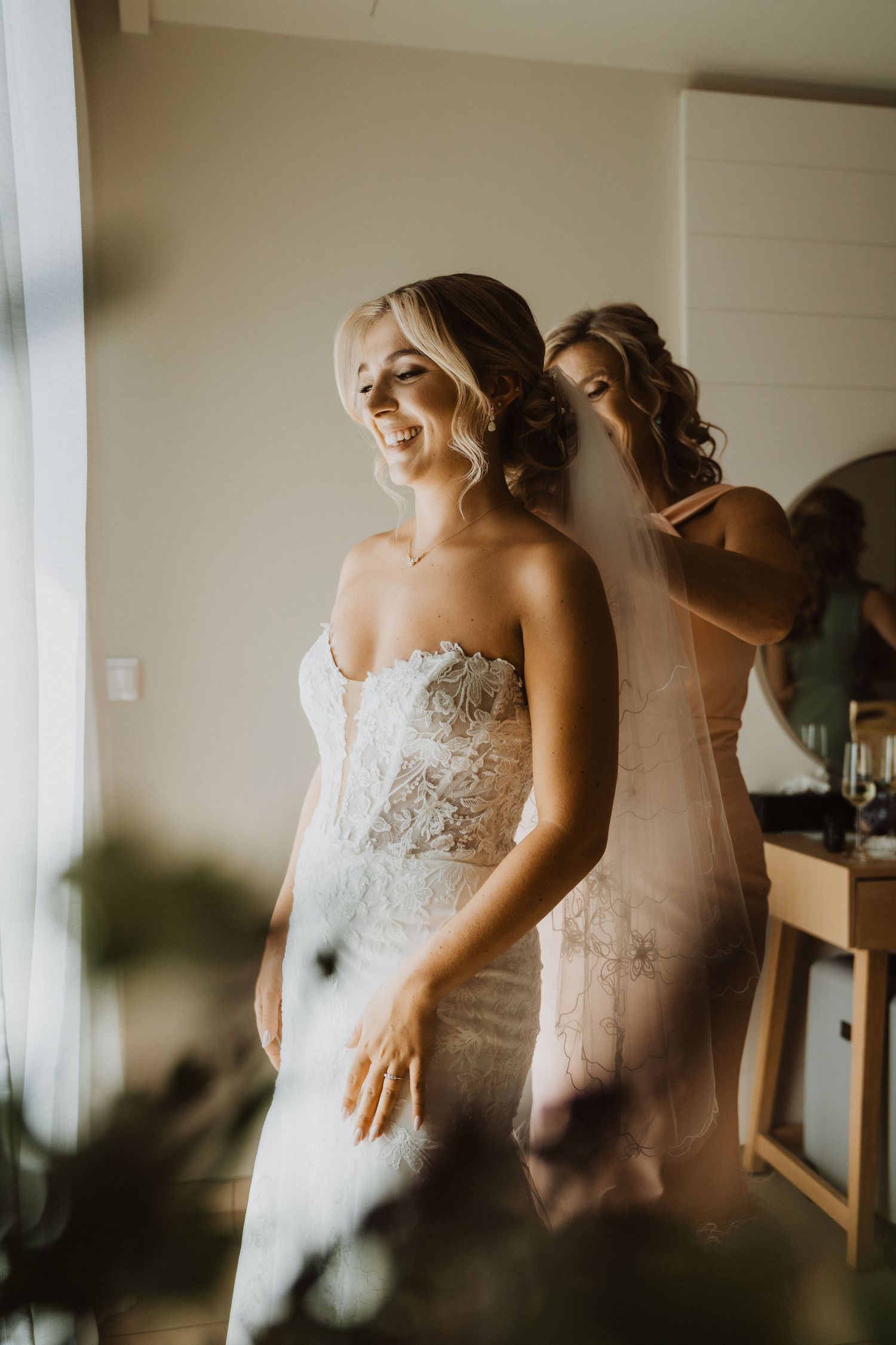 Candid getting ready moment in soft natural light.