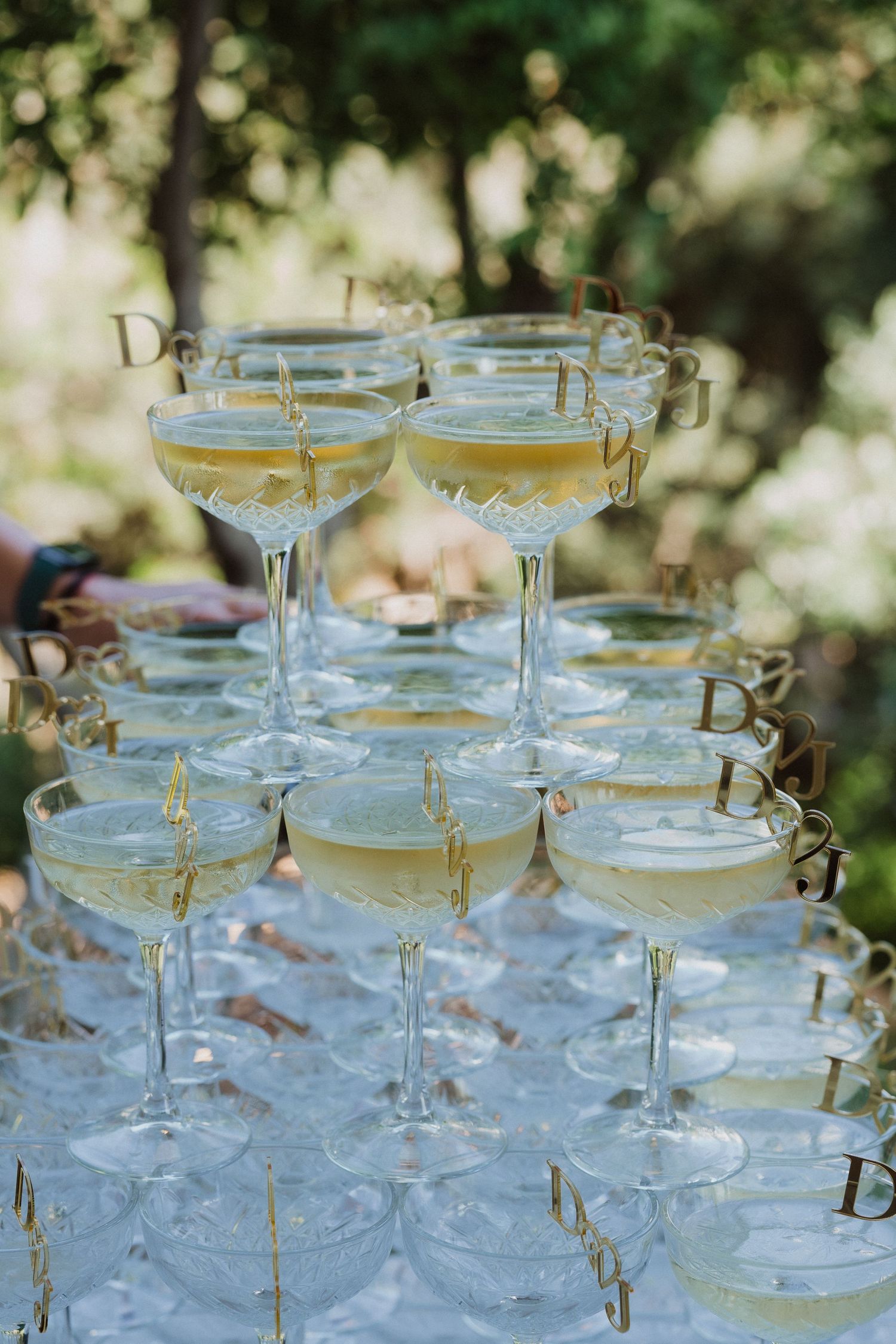 Elegant champagne glasses arranged in tiers on a reflective surface with delicate gold accents.