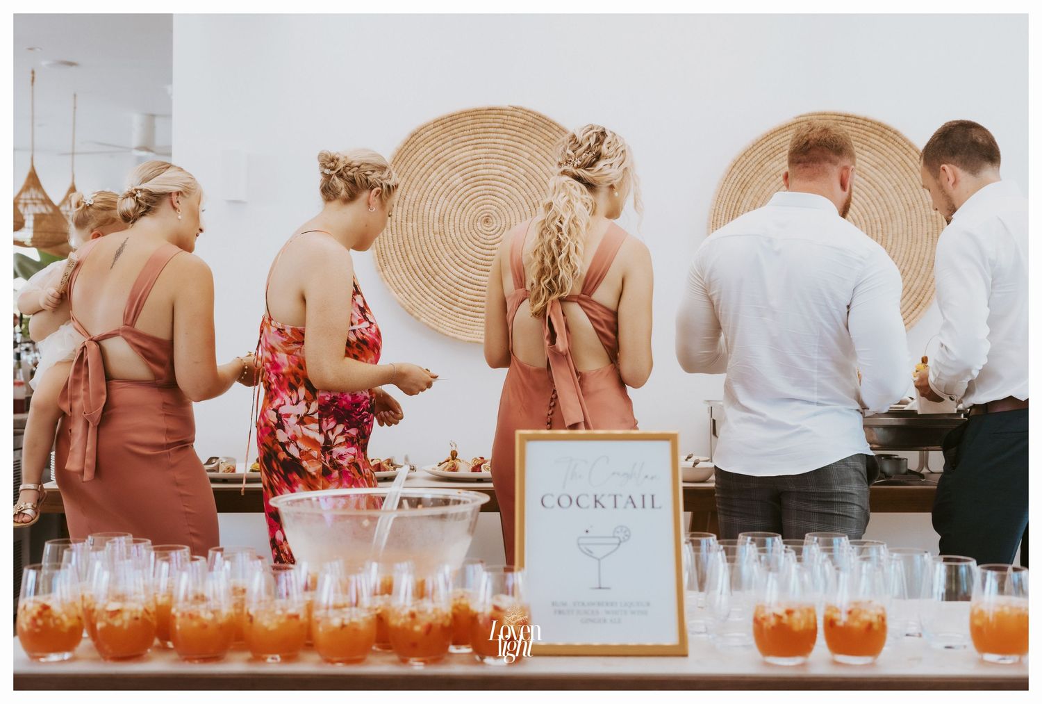 Wedding guests gathered around a cocktail bar with woven decorative elements.