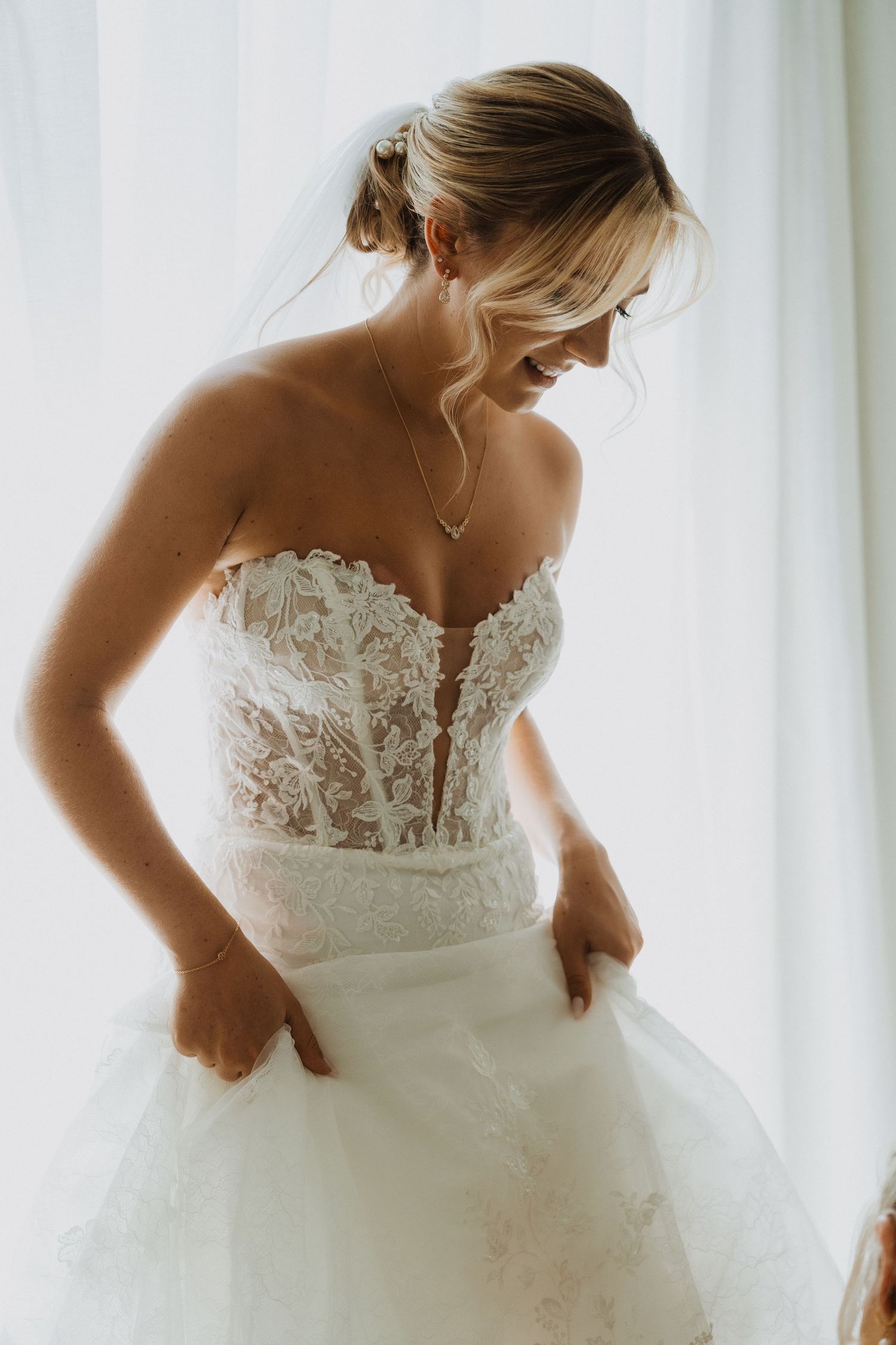 Back detail of wedding gown showing delicate lace and button closure.