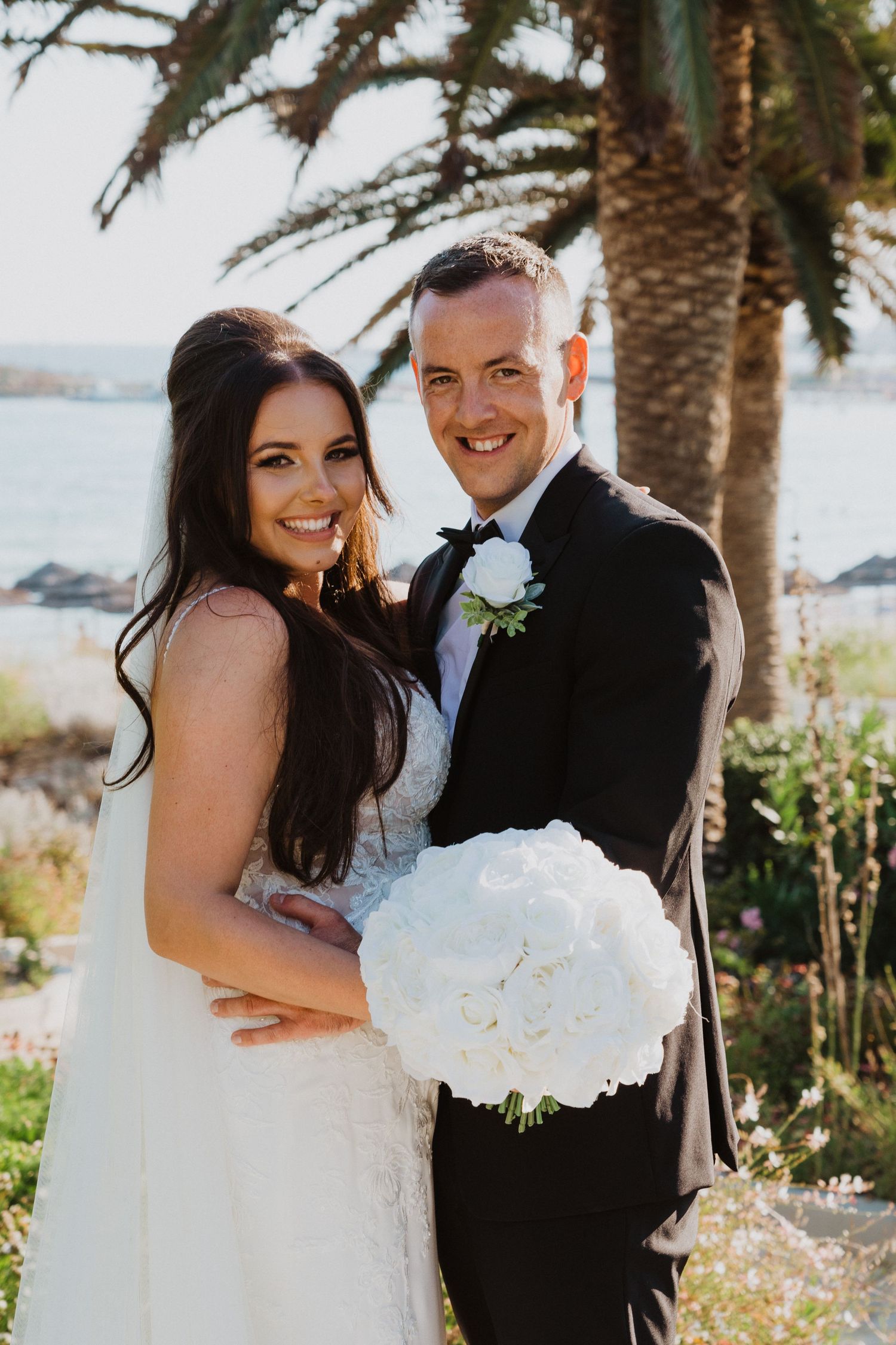 A joyful wedding celebration photographed in a lush tropical garden setting.