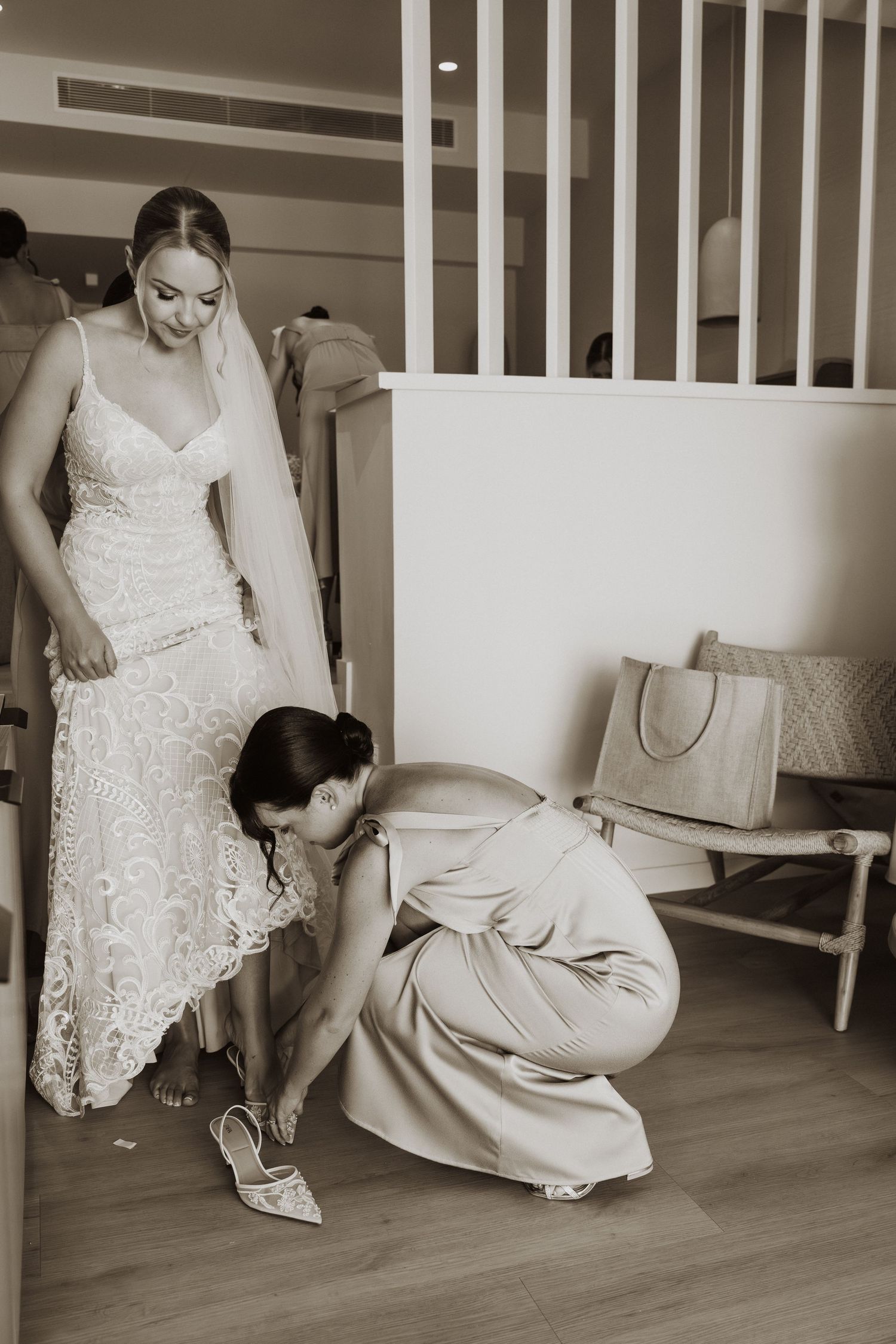 Sequence of wedding dress preparation shots showing white lace gown being adjusted on floor level.