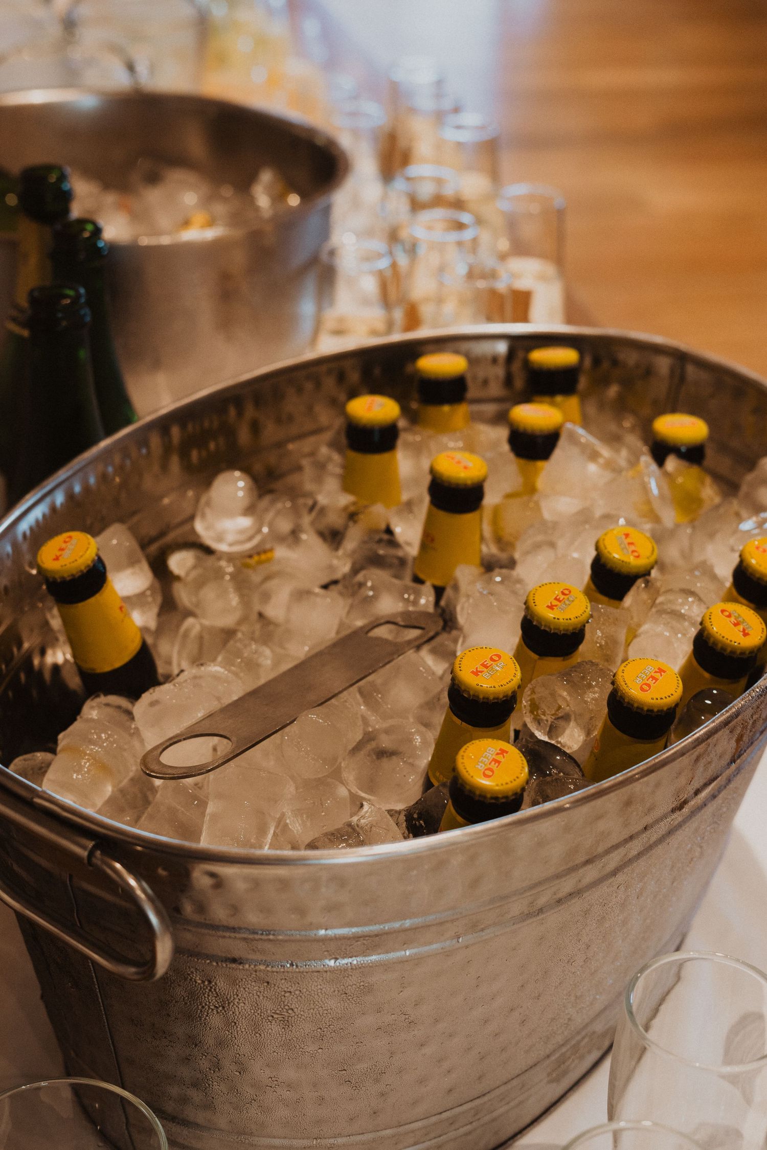 Metal bucket filled with beer bottles on ice at a wedding reception.
