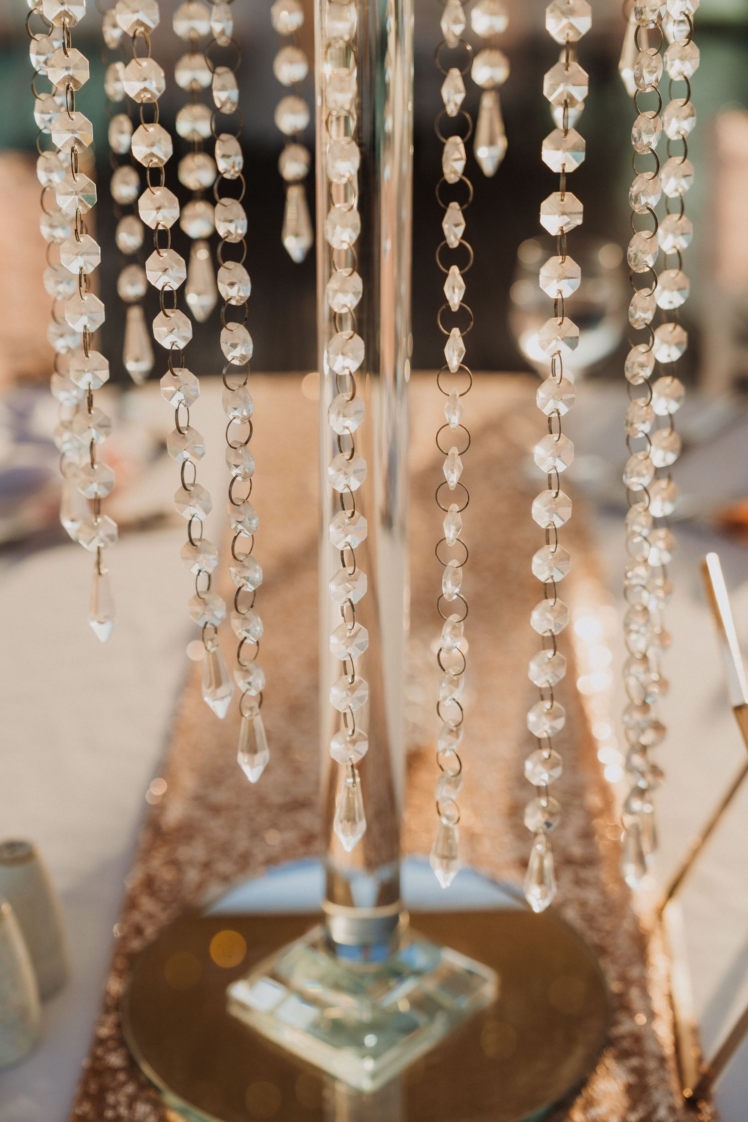 Crystal chandelier drops hanging elegantly against a blurred background creating a luxurious wedding decor element.