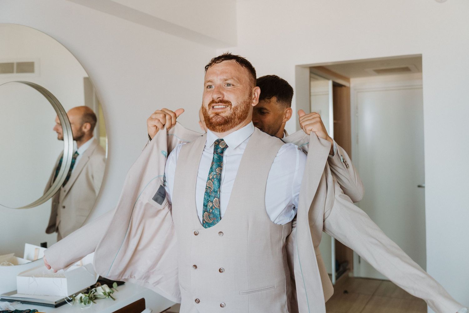 A formal event preparation scene showing traditional menswear attire and getting ready activities.