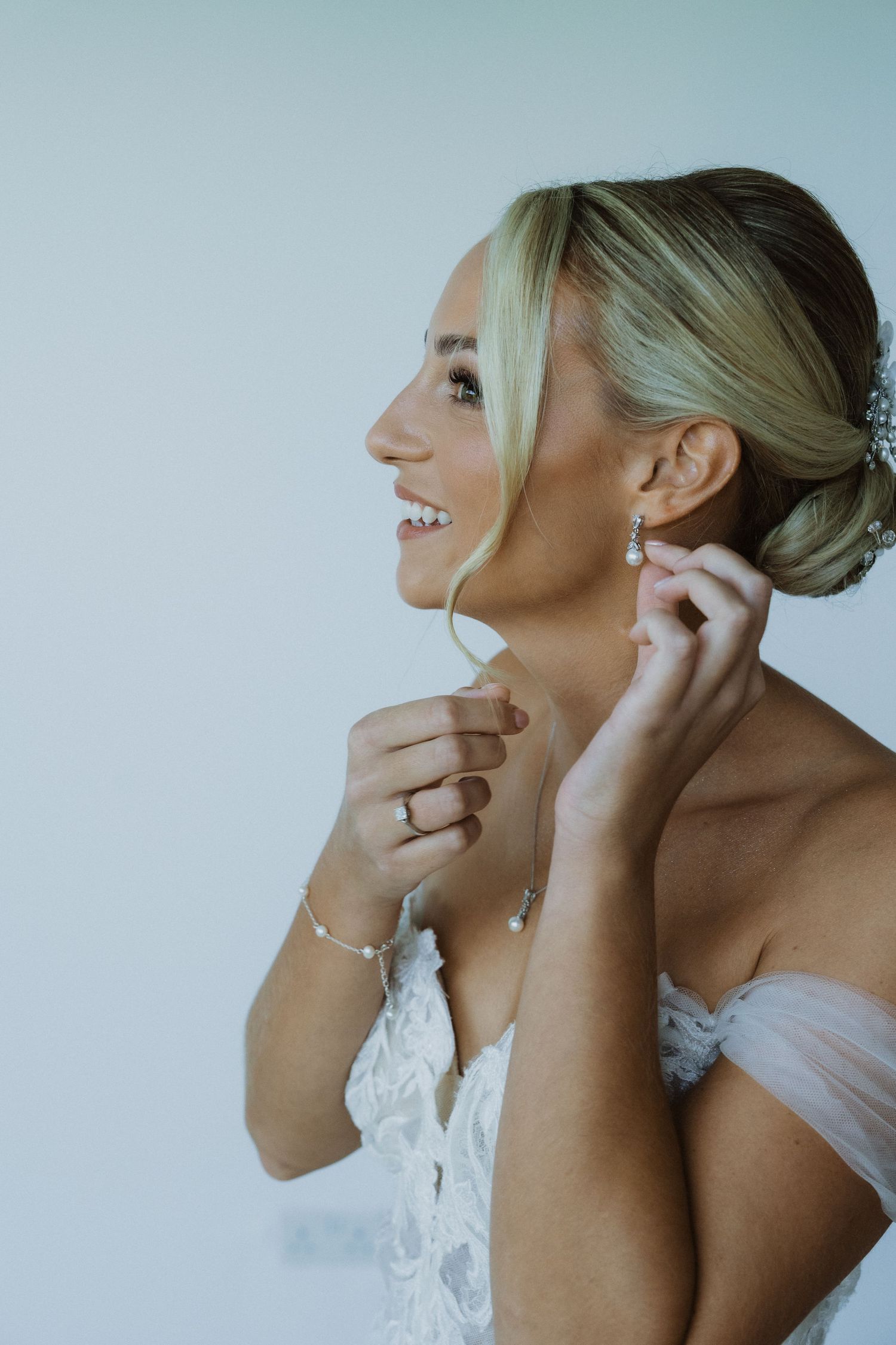 Close-up shots showing jewelry and accessories being put on during wedding preparations.