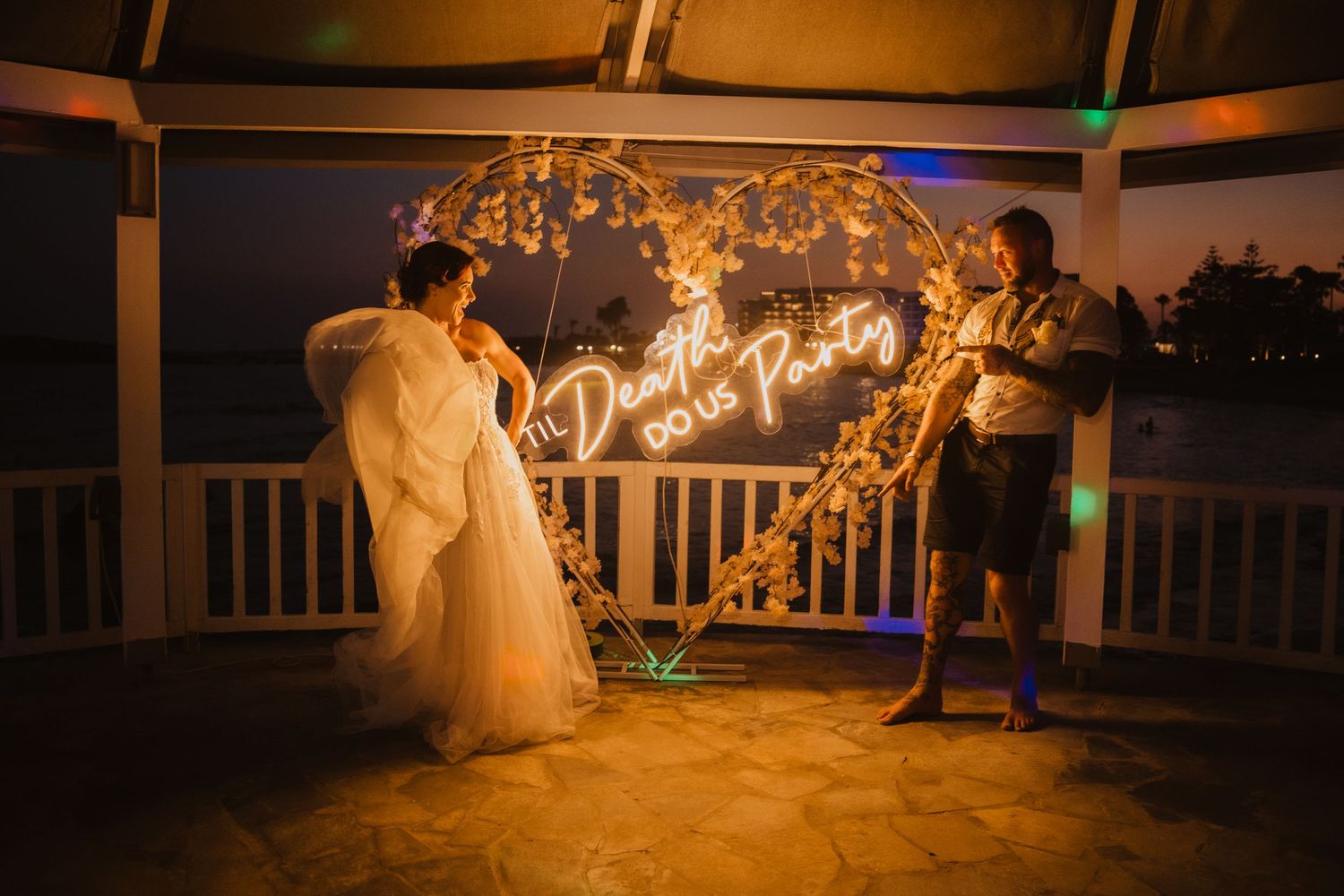 String lights and sparklers create a magical nighttime moment on an outdoor wedding venue balcony.