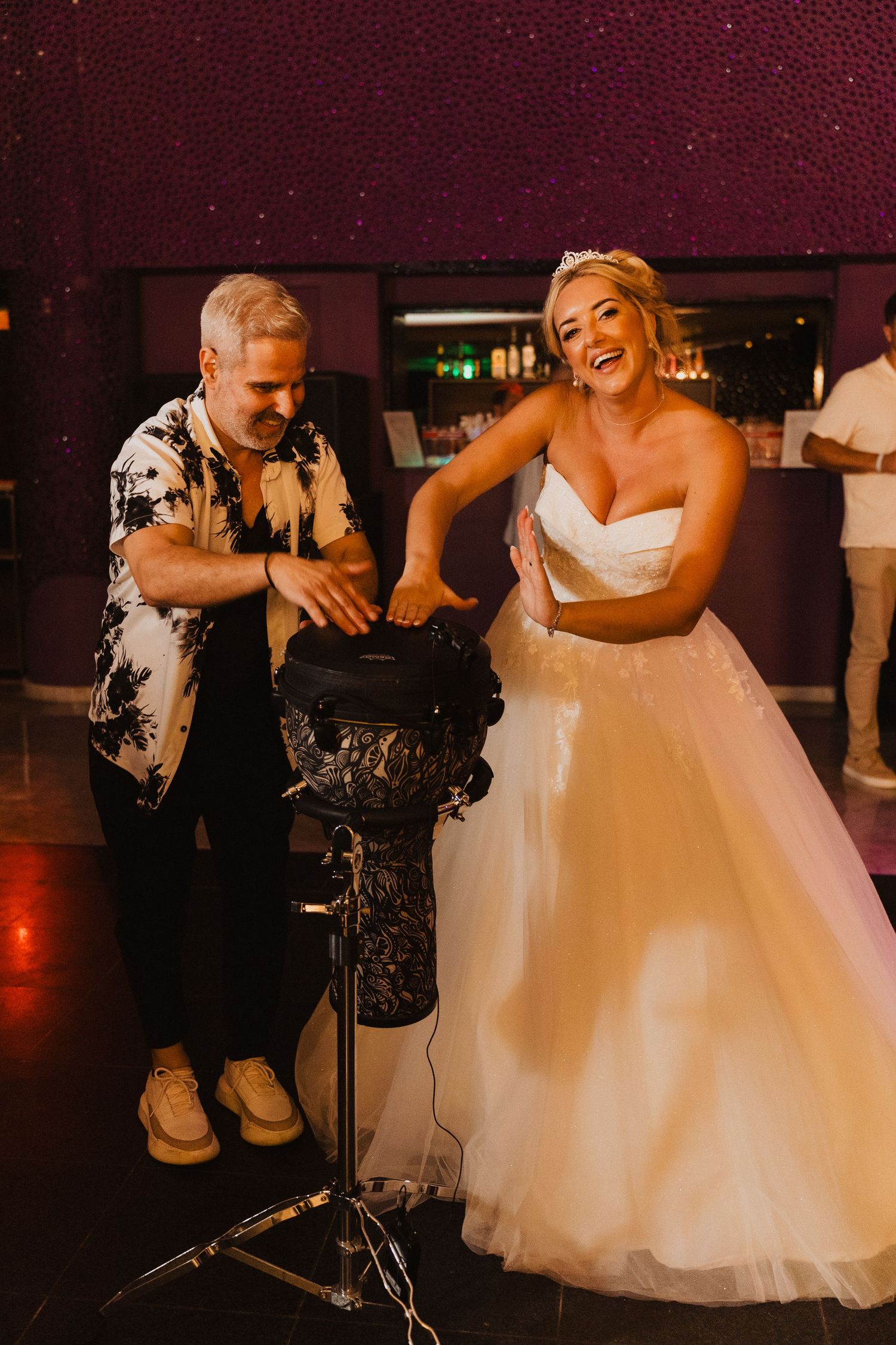 A joyful wedding celebration moment with laughter and dance moves shown on an indoor dance floor.