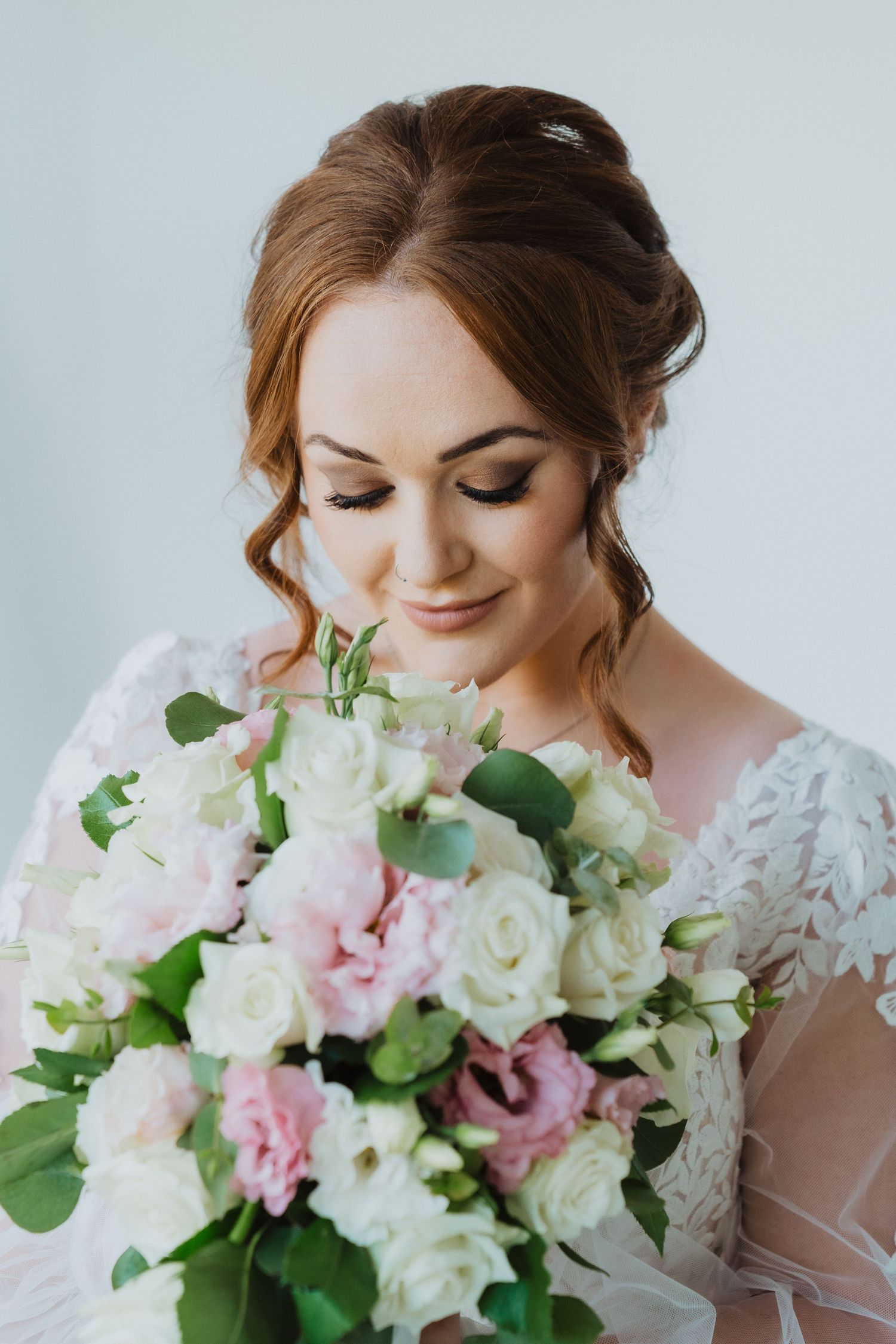 Close-up portrait showing bridal makeup and romantic updo hairstyle.