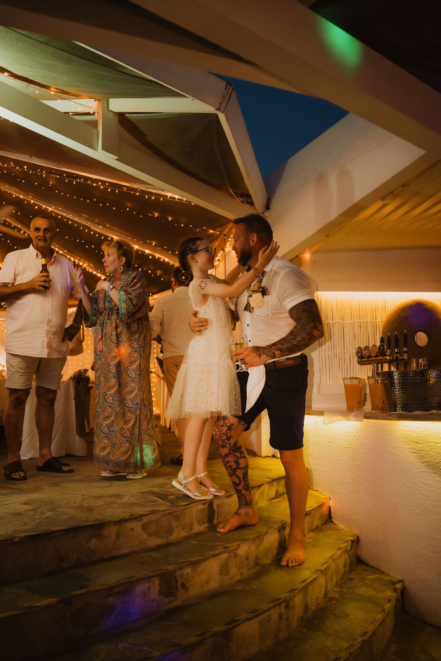 Evening wedding reception with couples dancing on illuminated outdoor steps.