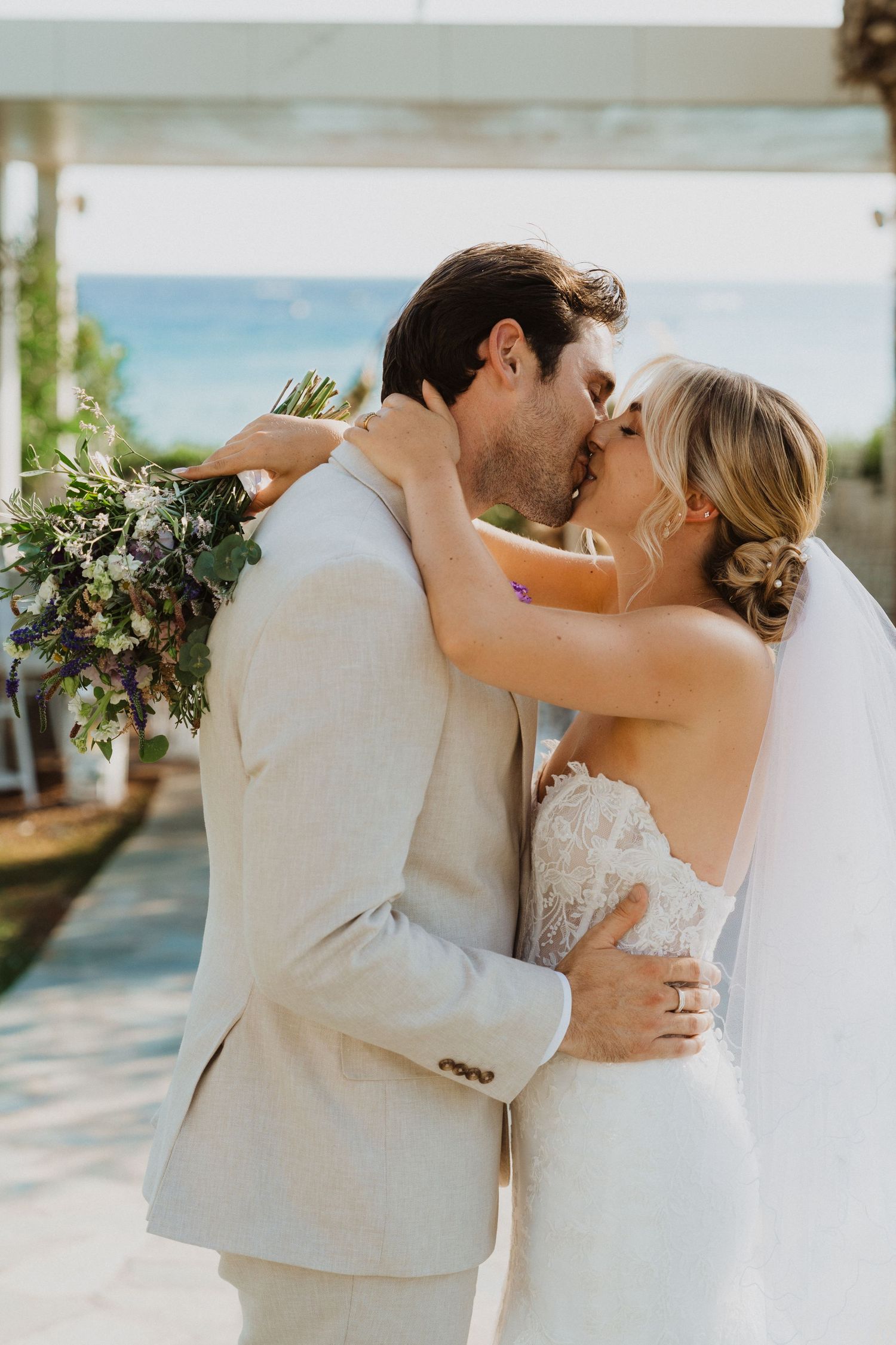 Intimate wedding portraits capture tender moments between couple at beachfront venue.