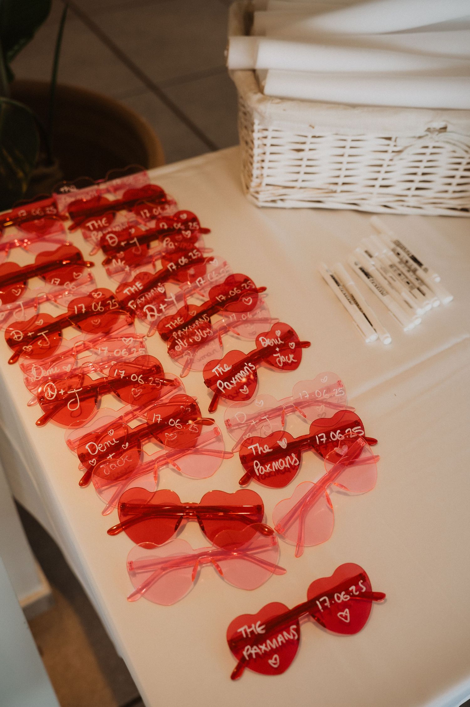 Red heart-shaped name tags with pink ribbons arranged neatly on a white surface for event seating.