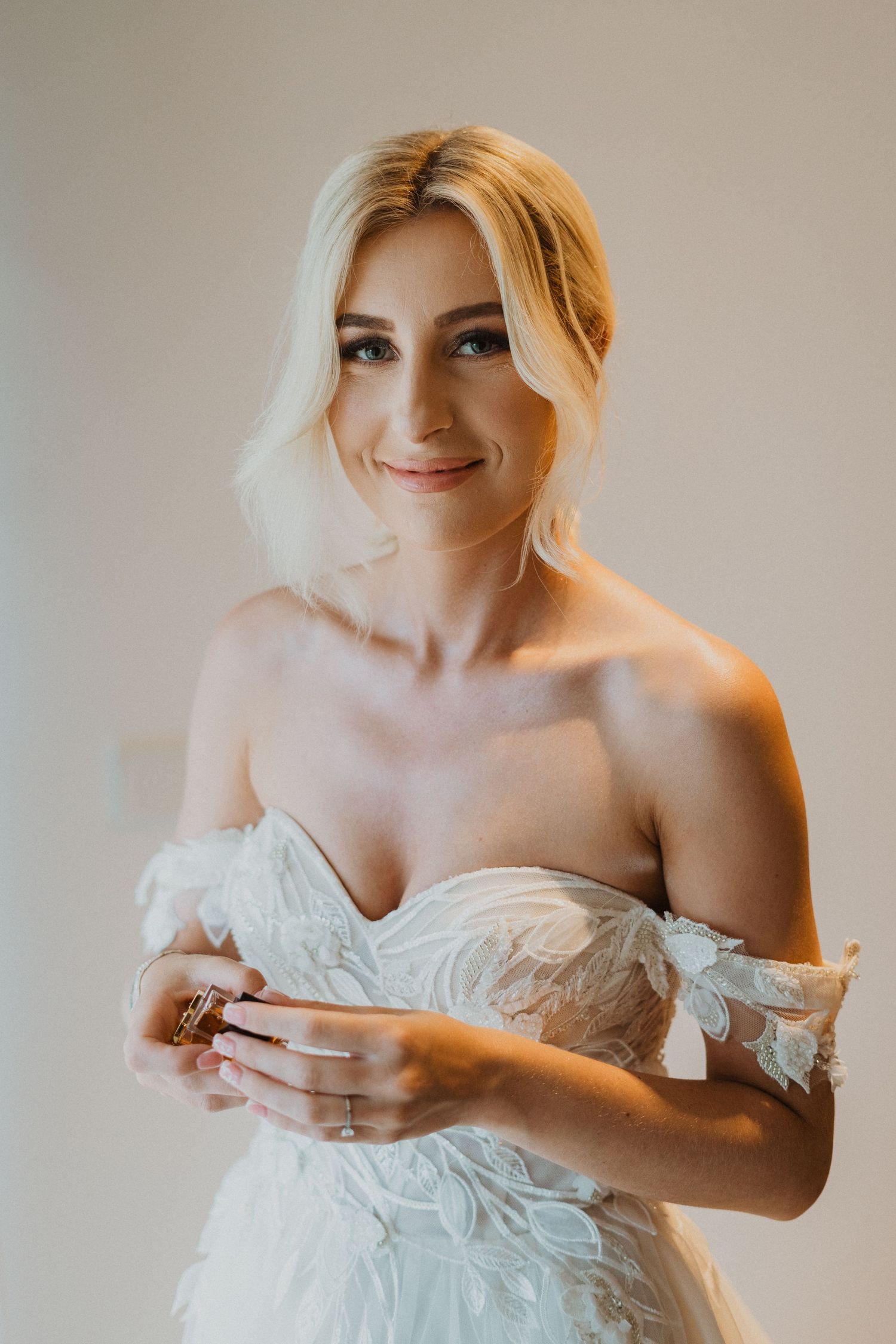 Close-up bridal portrait showcasing delicate off-shoulder wedding dress details.