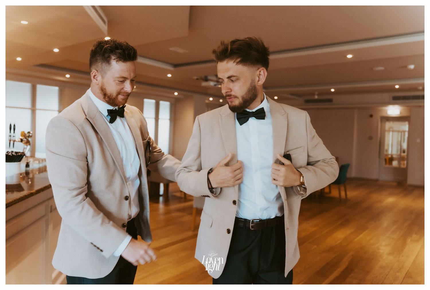 Groomsmen in matching beige jackets and bowties adjusting their attire before the ceremony.