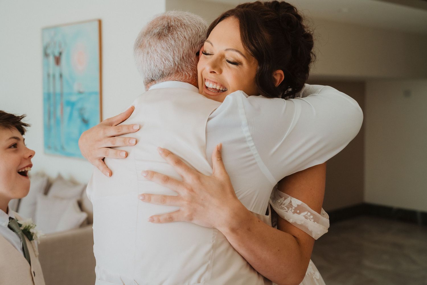 A joyful emotional embrace shared between people in a brightly lit indoor setting.